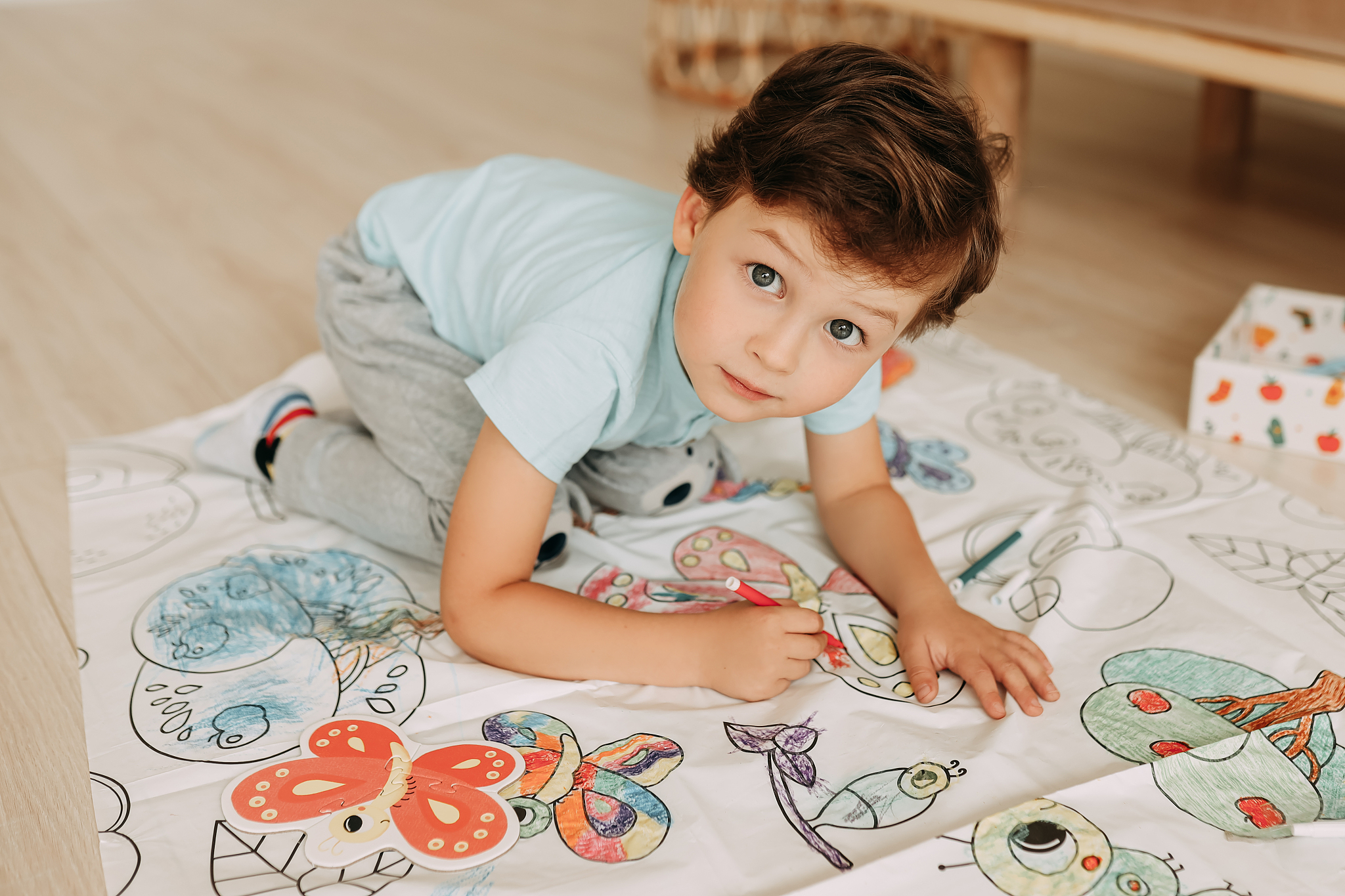 boy teenager in home clothes plays and paints drawings while sit