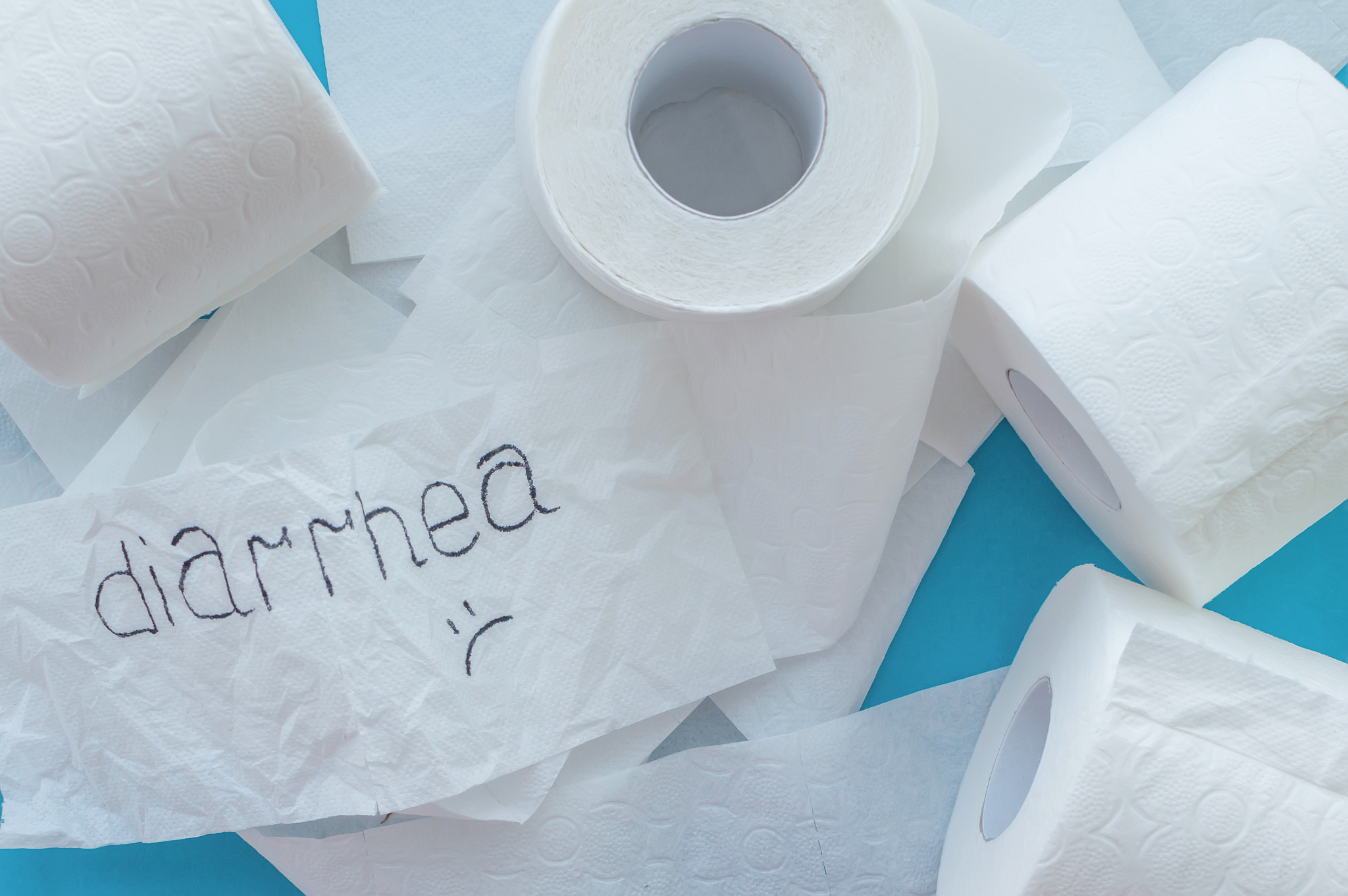rolls of white toilet paper labeled "diarrhea" on a blue backgro