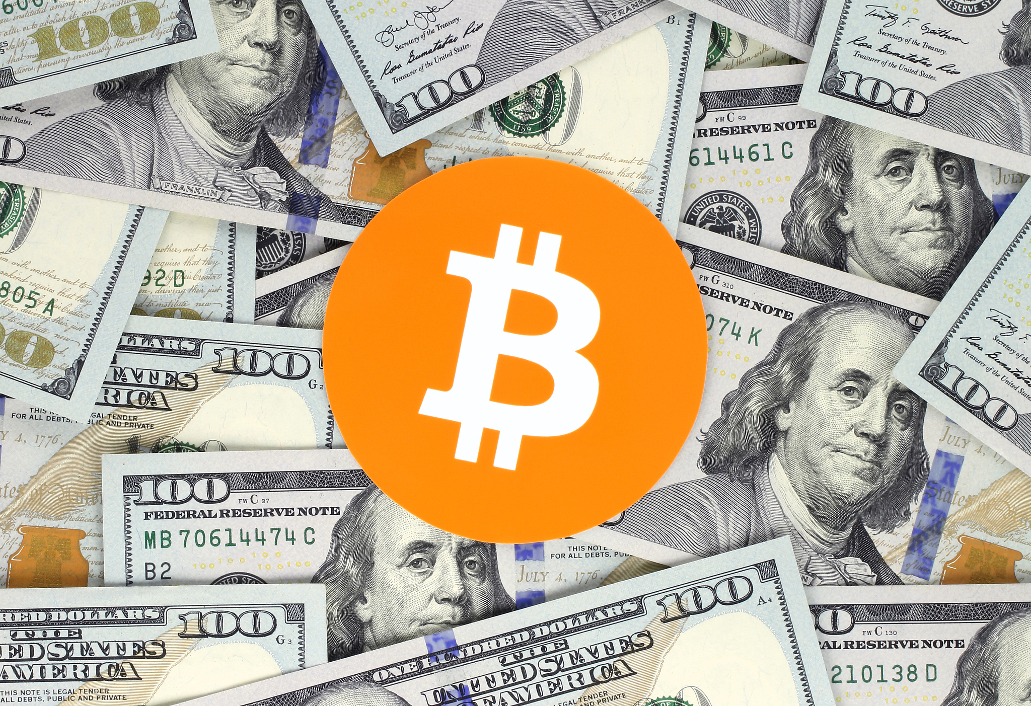 bitcoin on hundred dollars bills background