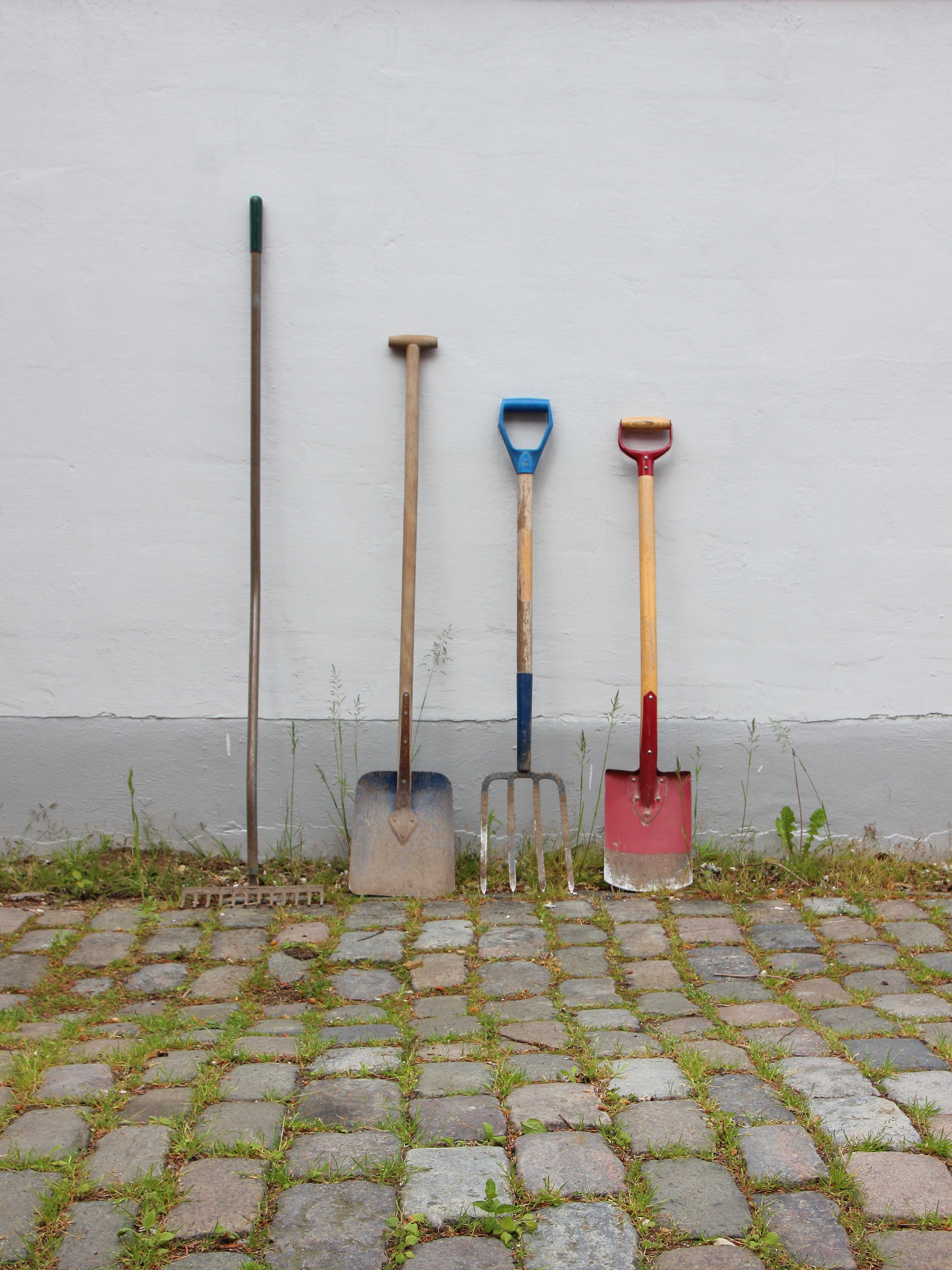 garden tools on cobble surface with wall