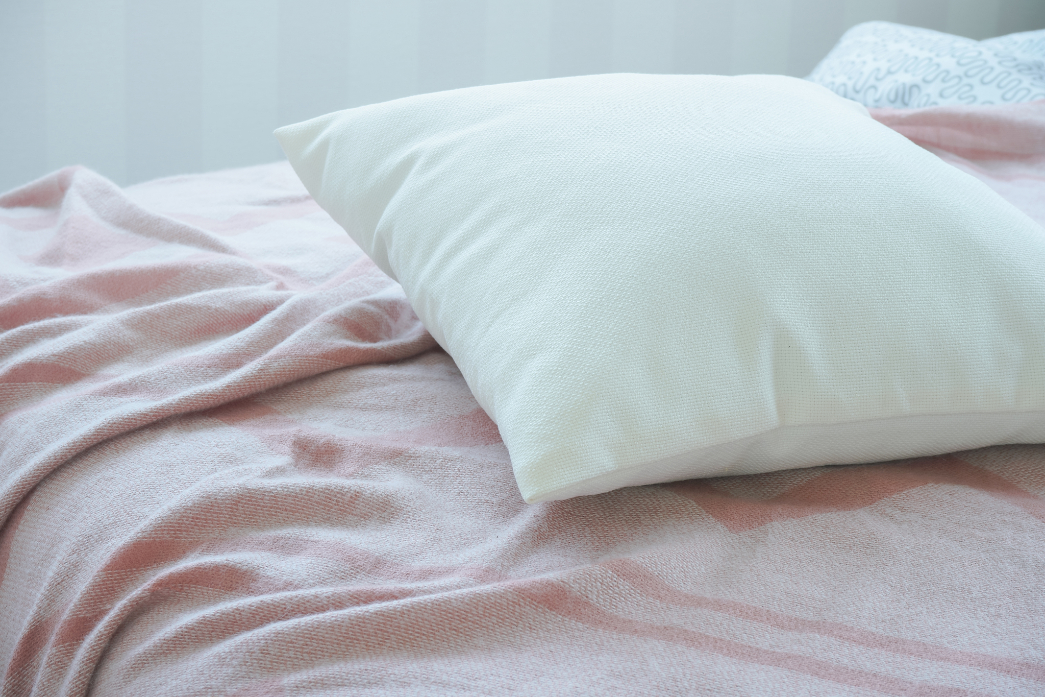 white pillow on pink messy bed