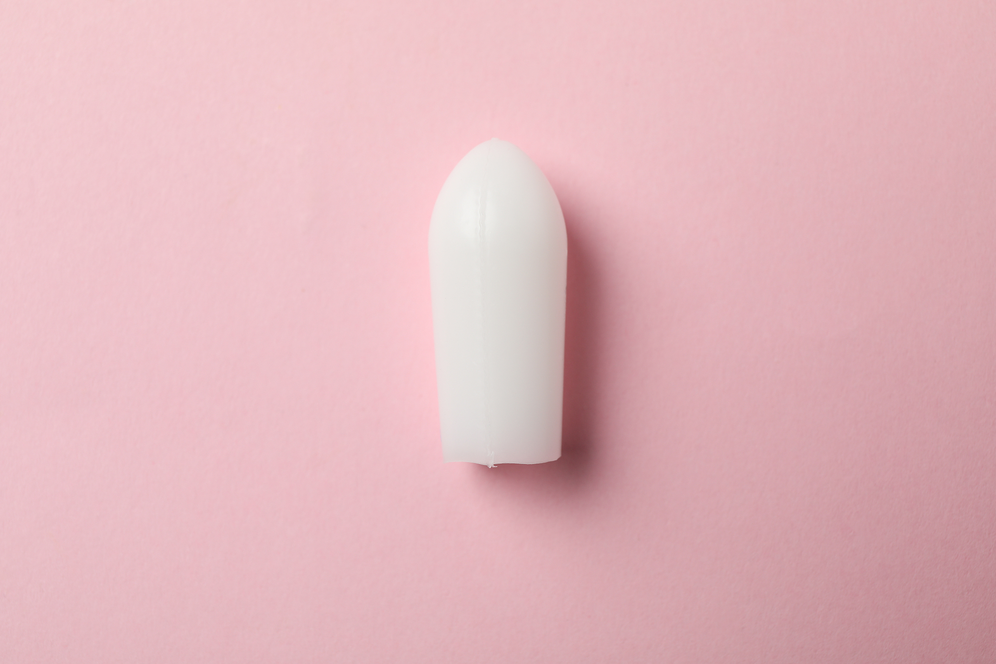 anal or vaginal candle on pink background, close up