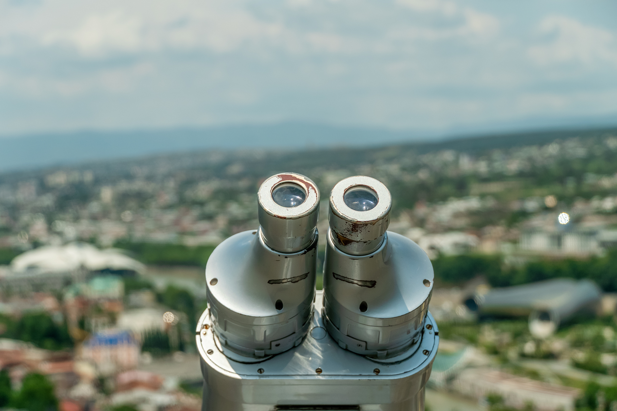 binoculars close-up overlooking tbilisi, the georgian capital in