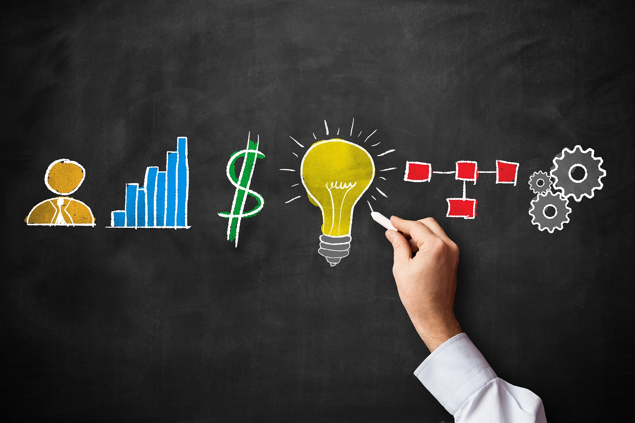 marketing icons on blackboard with human hand