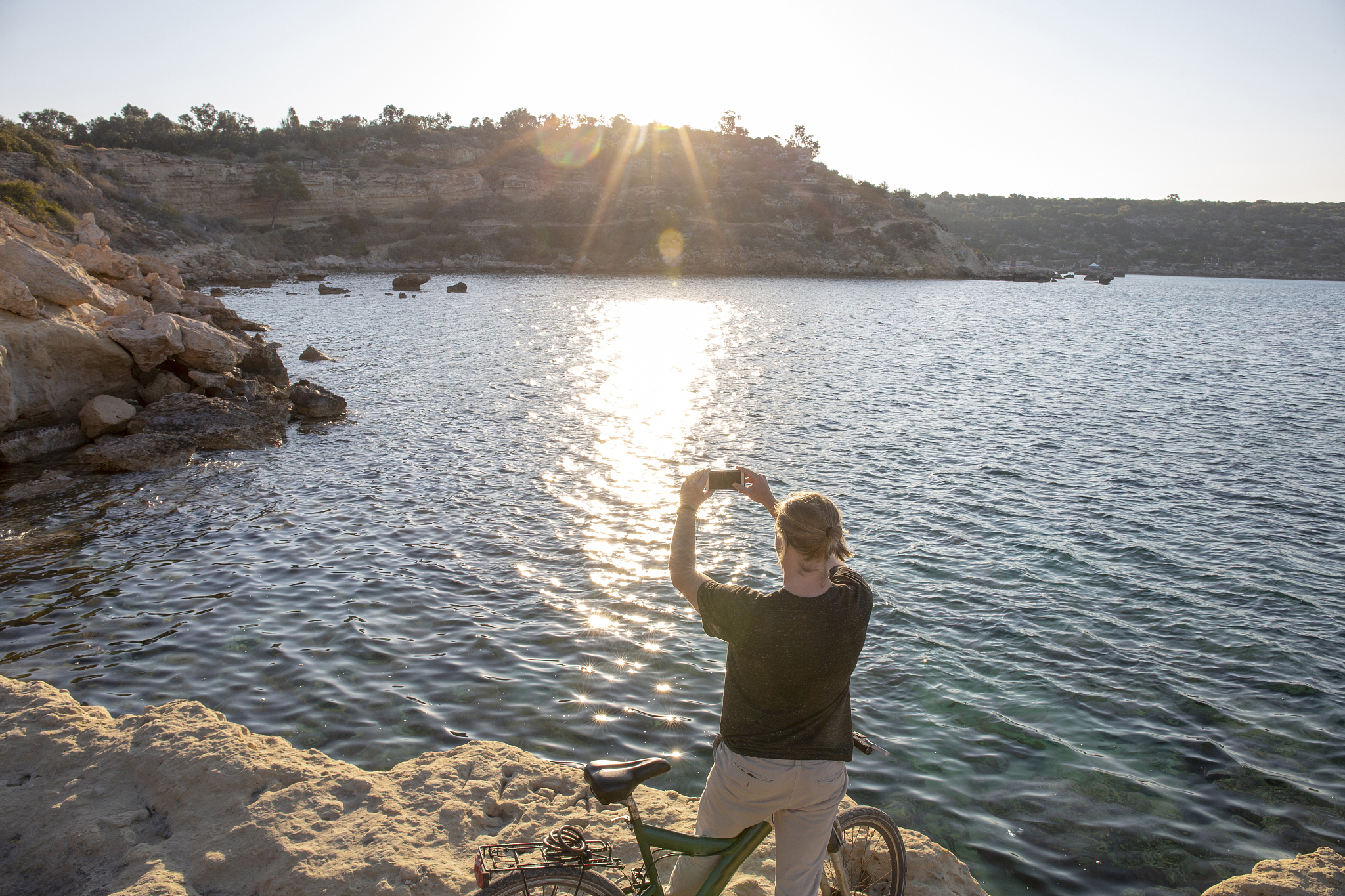 young man takes pictures in coastal desert setting