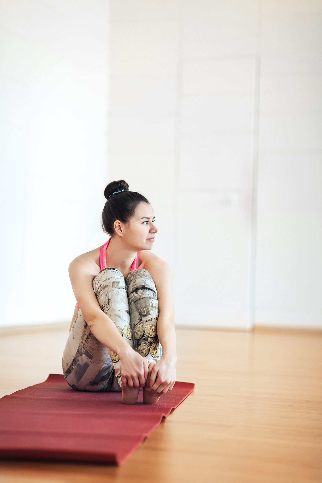 young woman in sports uniform sits in the hall, looks away, thou
