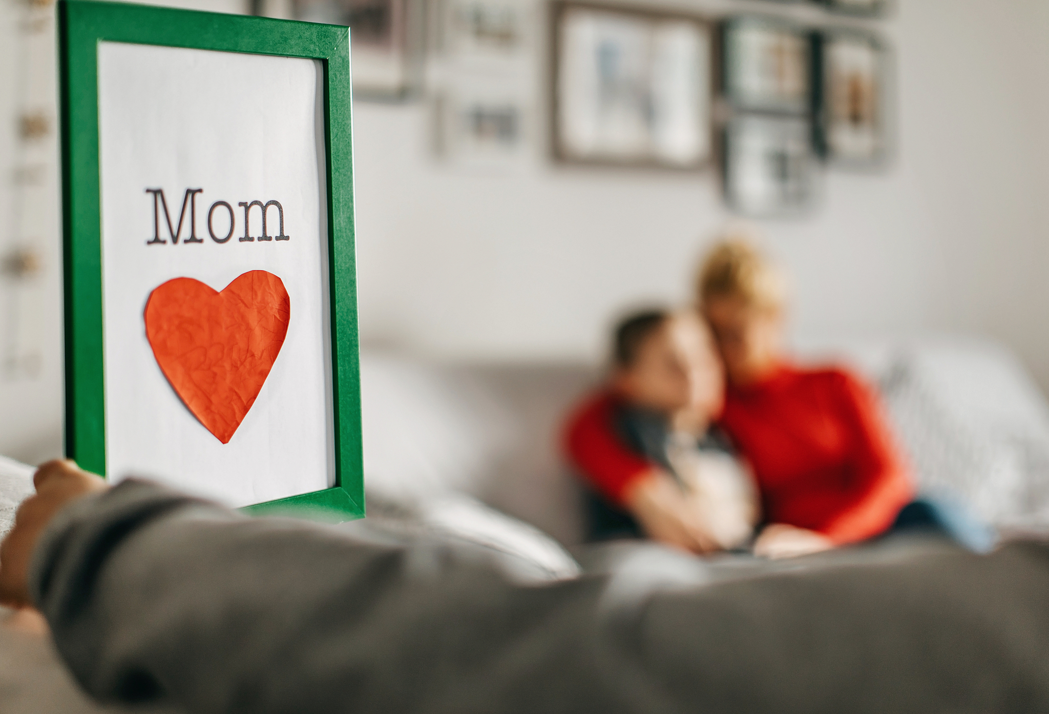 boy holding love mom sign
