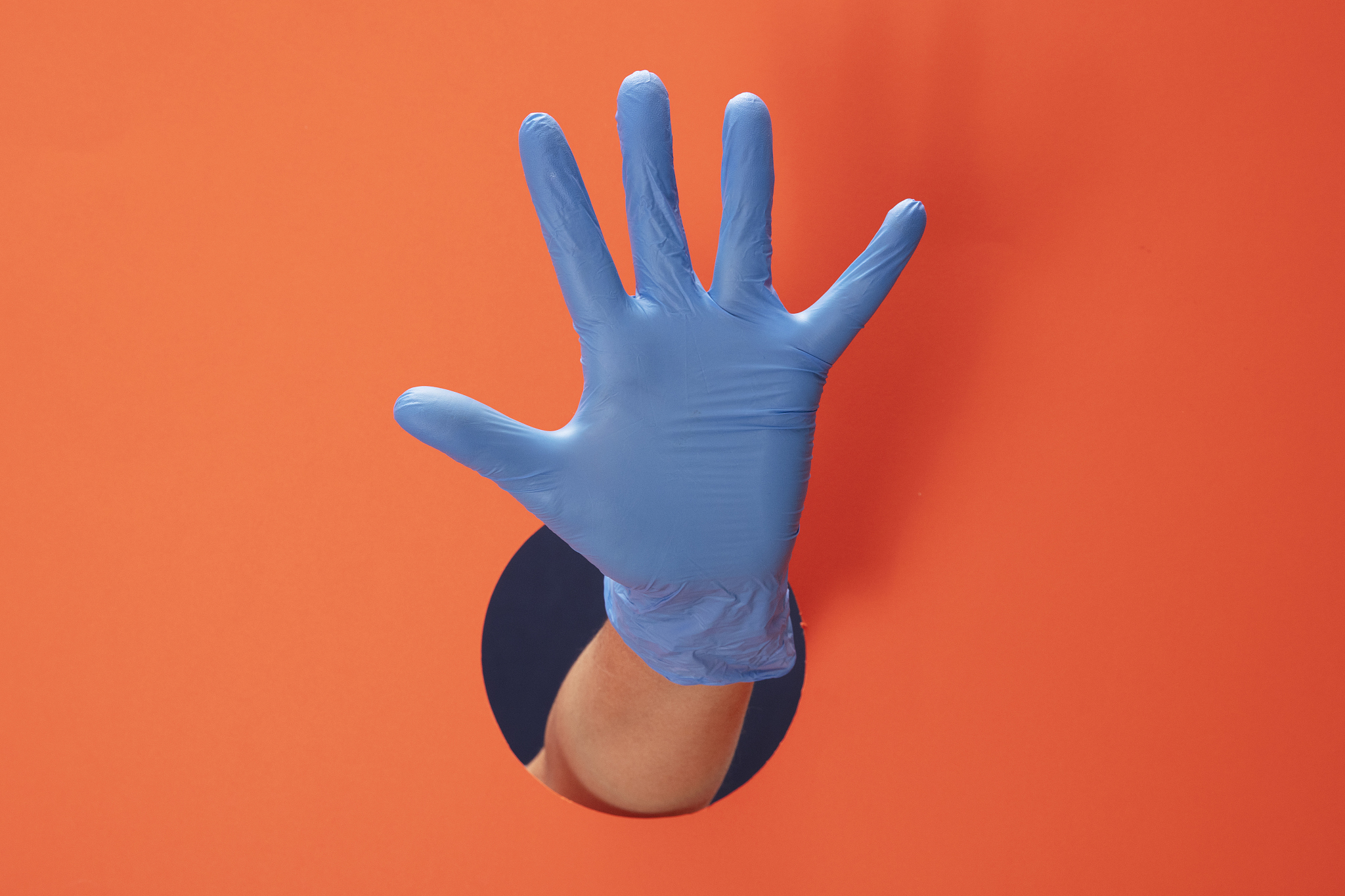 doctor hand with blue medical glove showing number five with fin