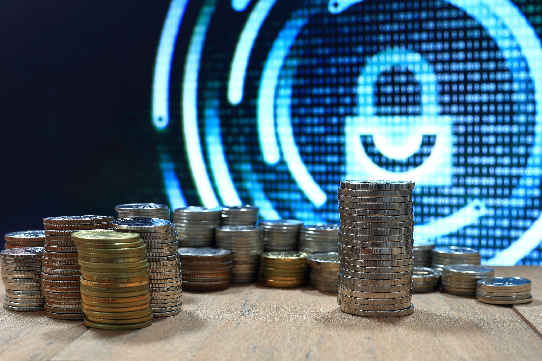 vintage digital economy coin pile stacked in to columns on woode