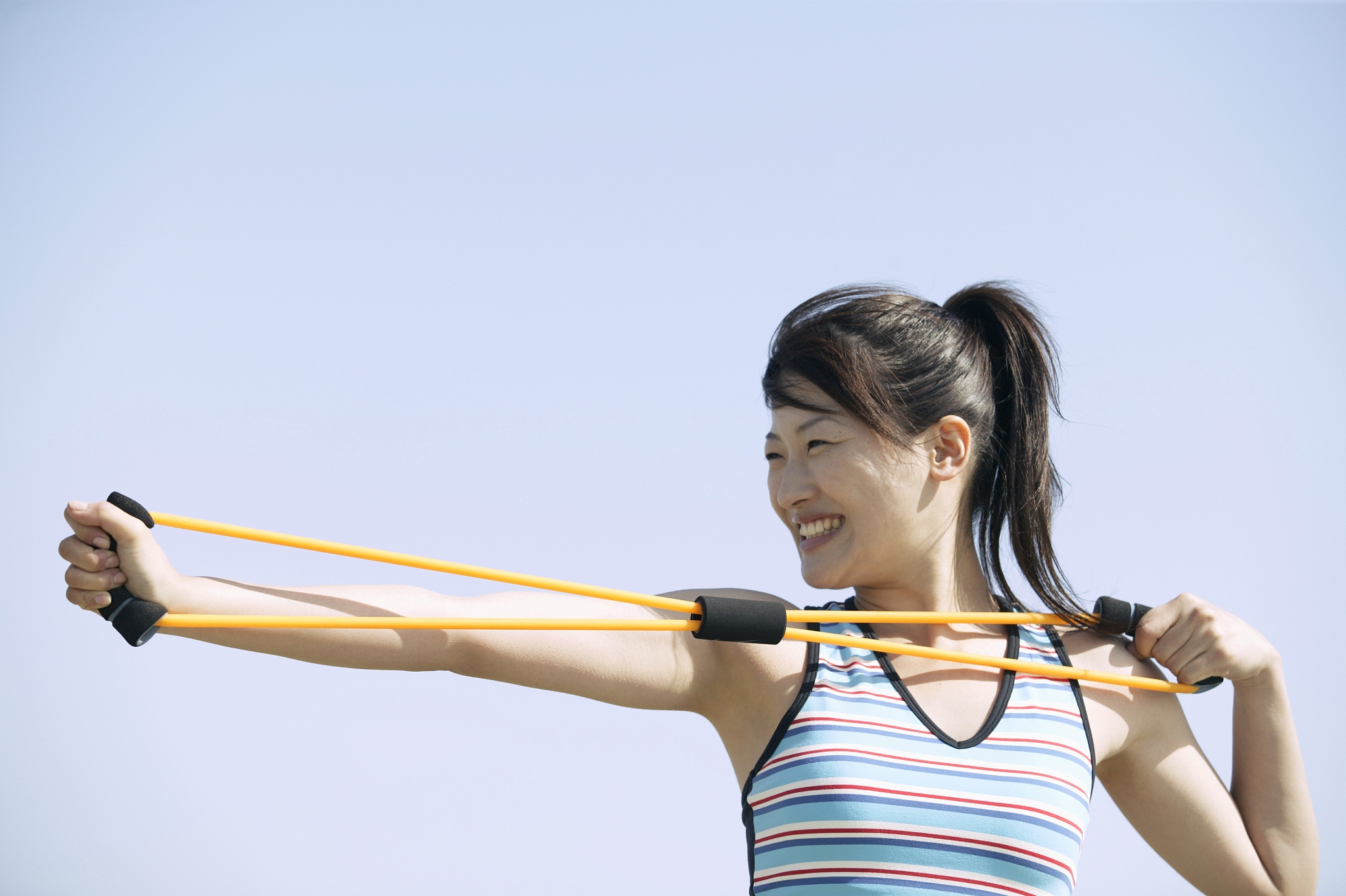 a woman working out as she stretches a rope tightly with her han