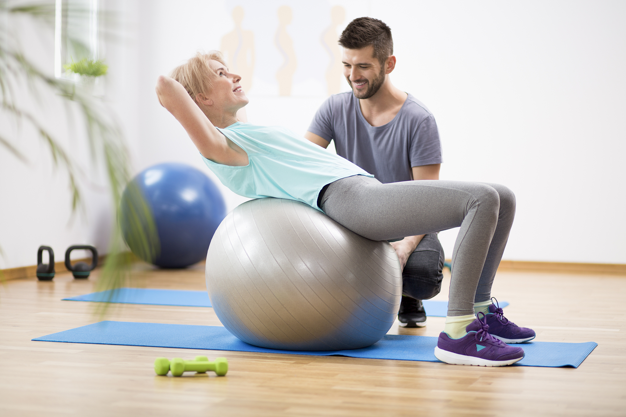 middle age blond woman exercising on gymnastic ball during sessi