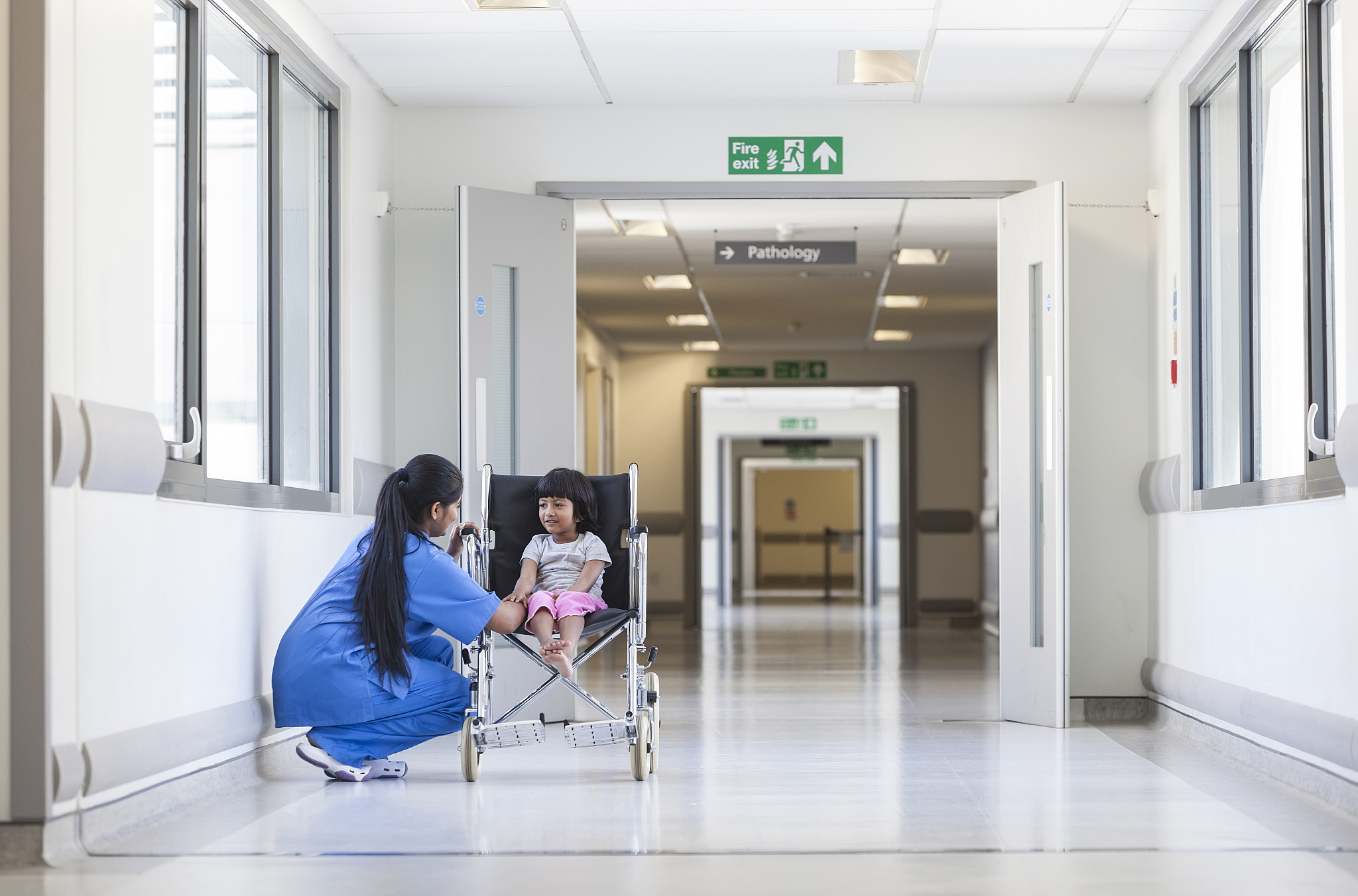 female girl child patient in wheelchair & hospital nurse