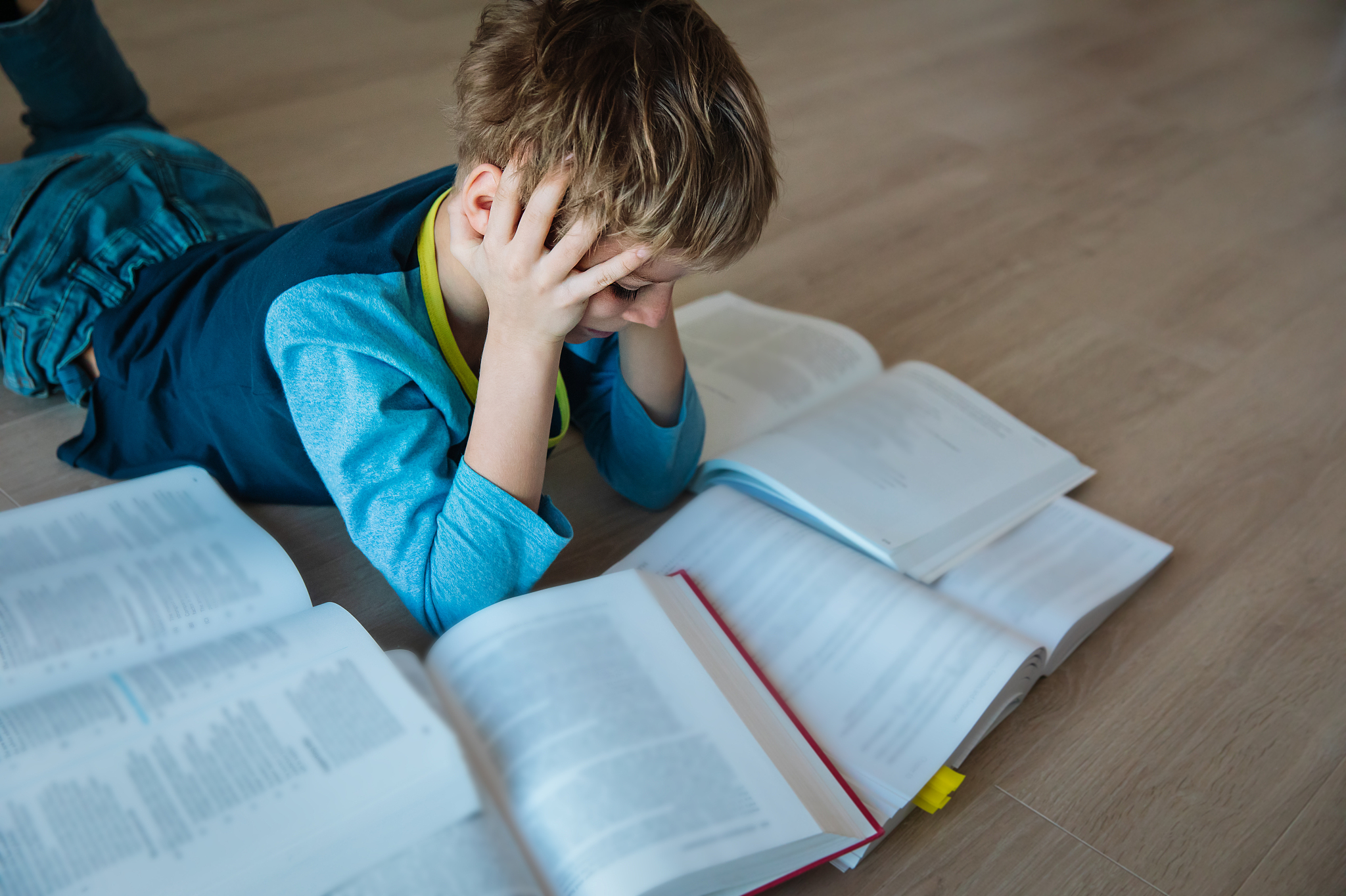 boy tired of reading, kid stressed by doing homework