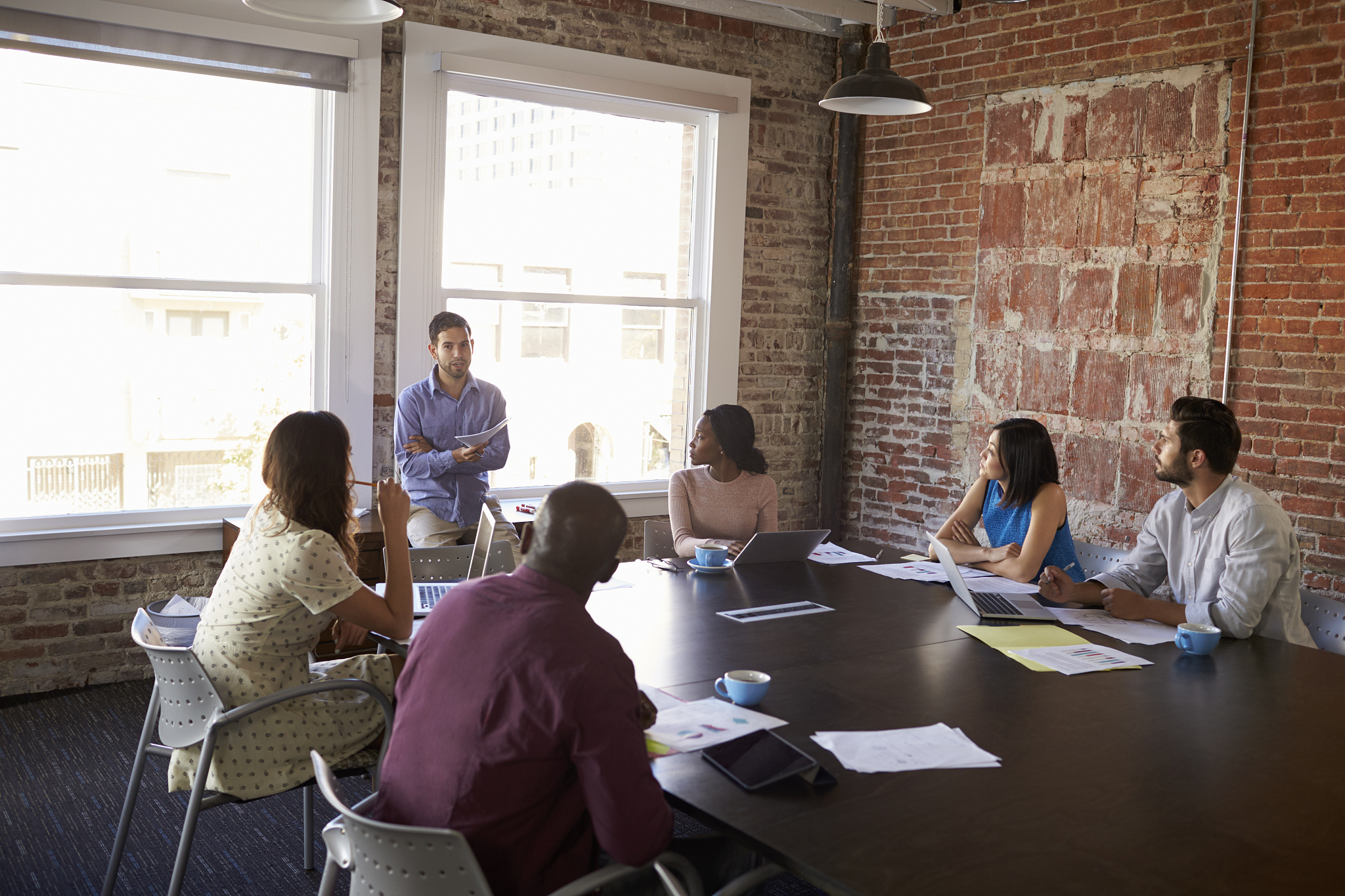 businessman standing to address boardroom meeting