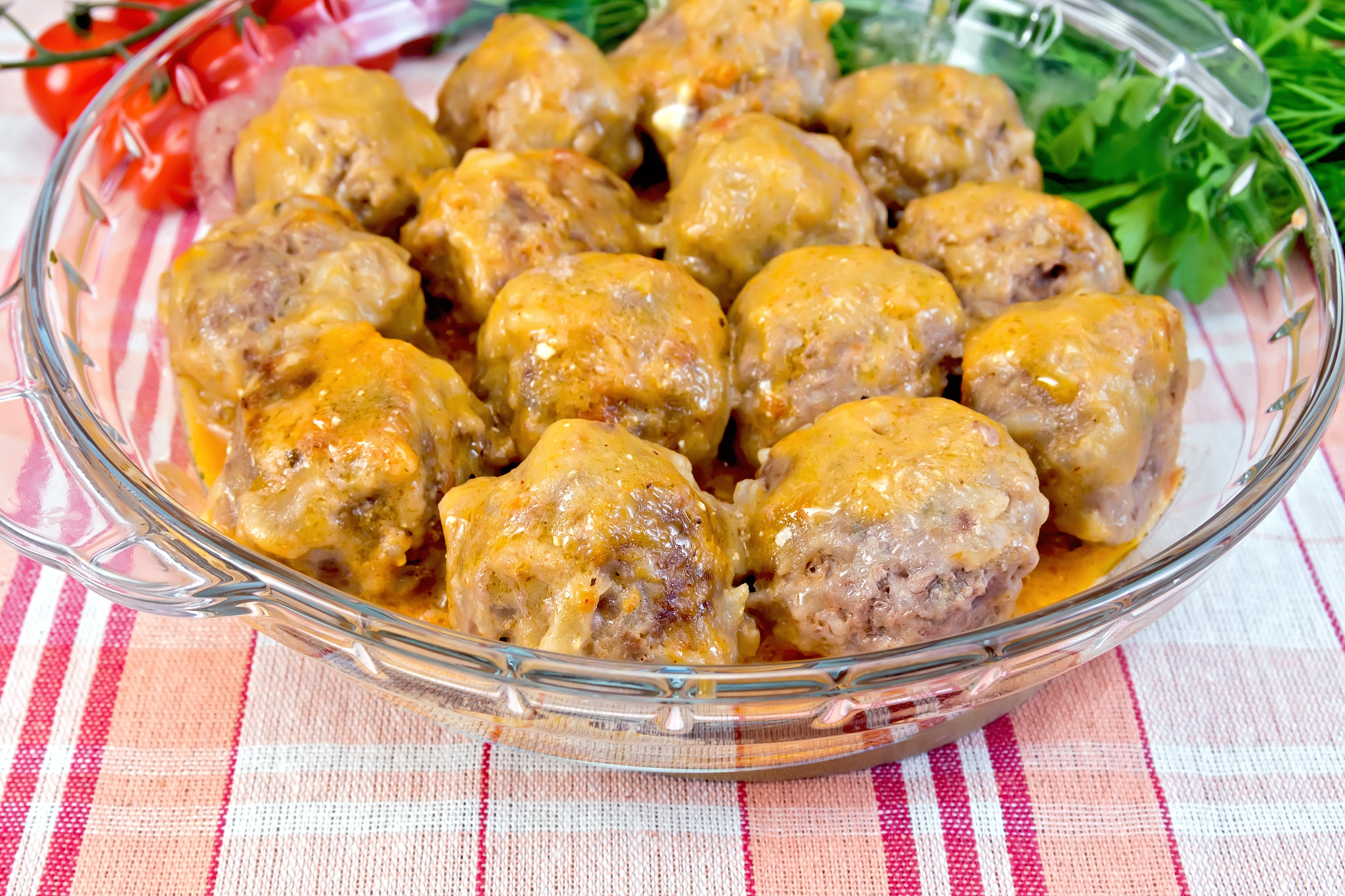 meatballs with sauce in glass pan on linen tablecloth