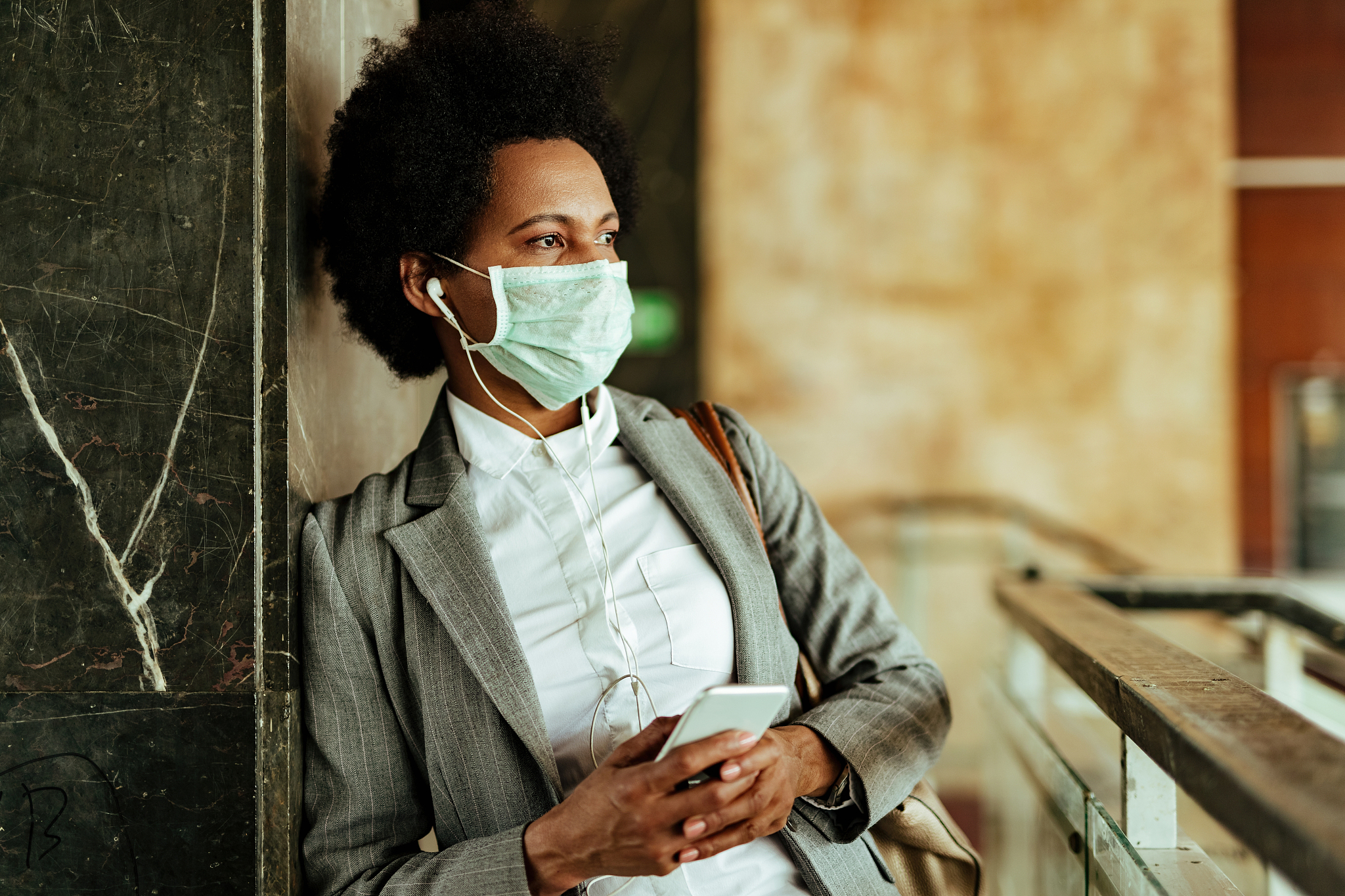 pensive black businesswoman wearing protective face mask while u