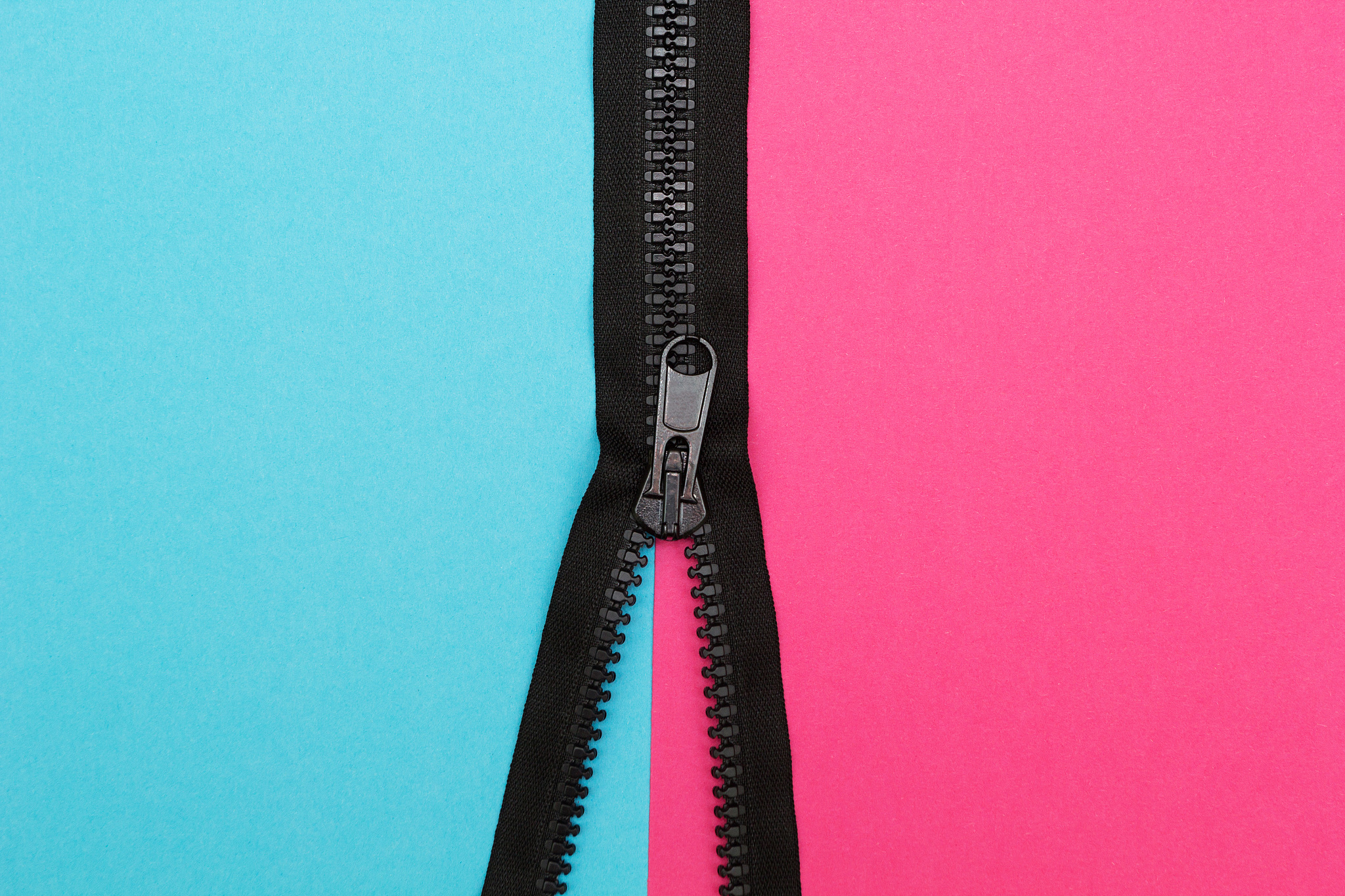 zipper on a pink and blue background, top view.