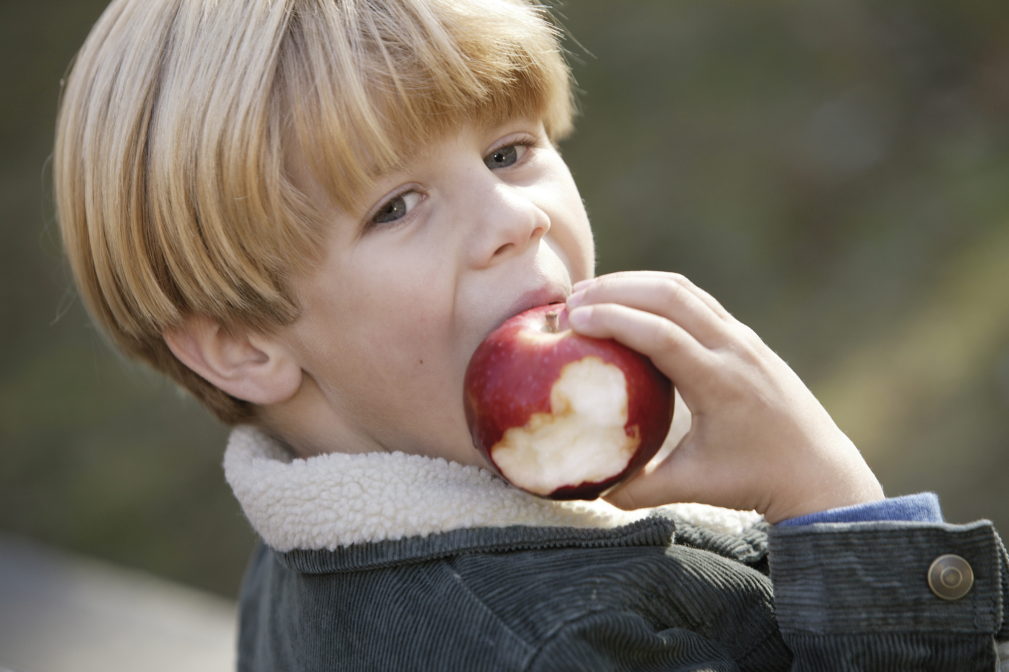 boy biting into apple