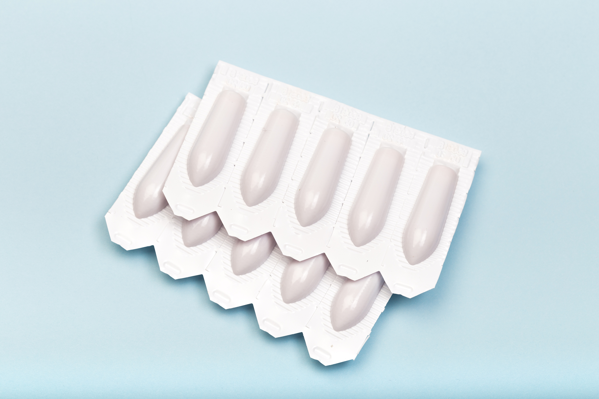 plastic packs of suppositories on blue