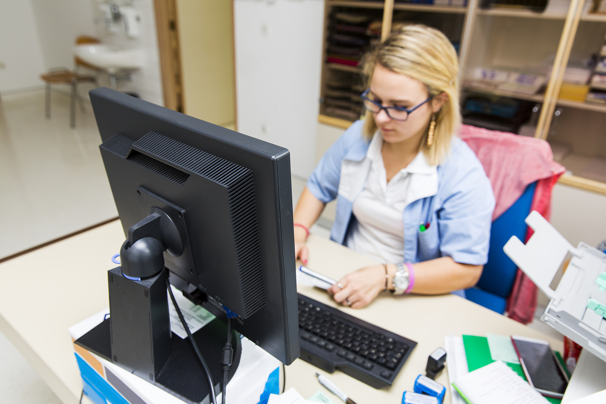 nurse in her office,working with computer,daily paperwork