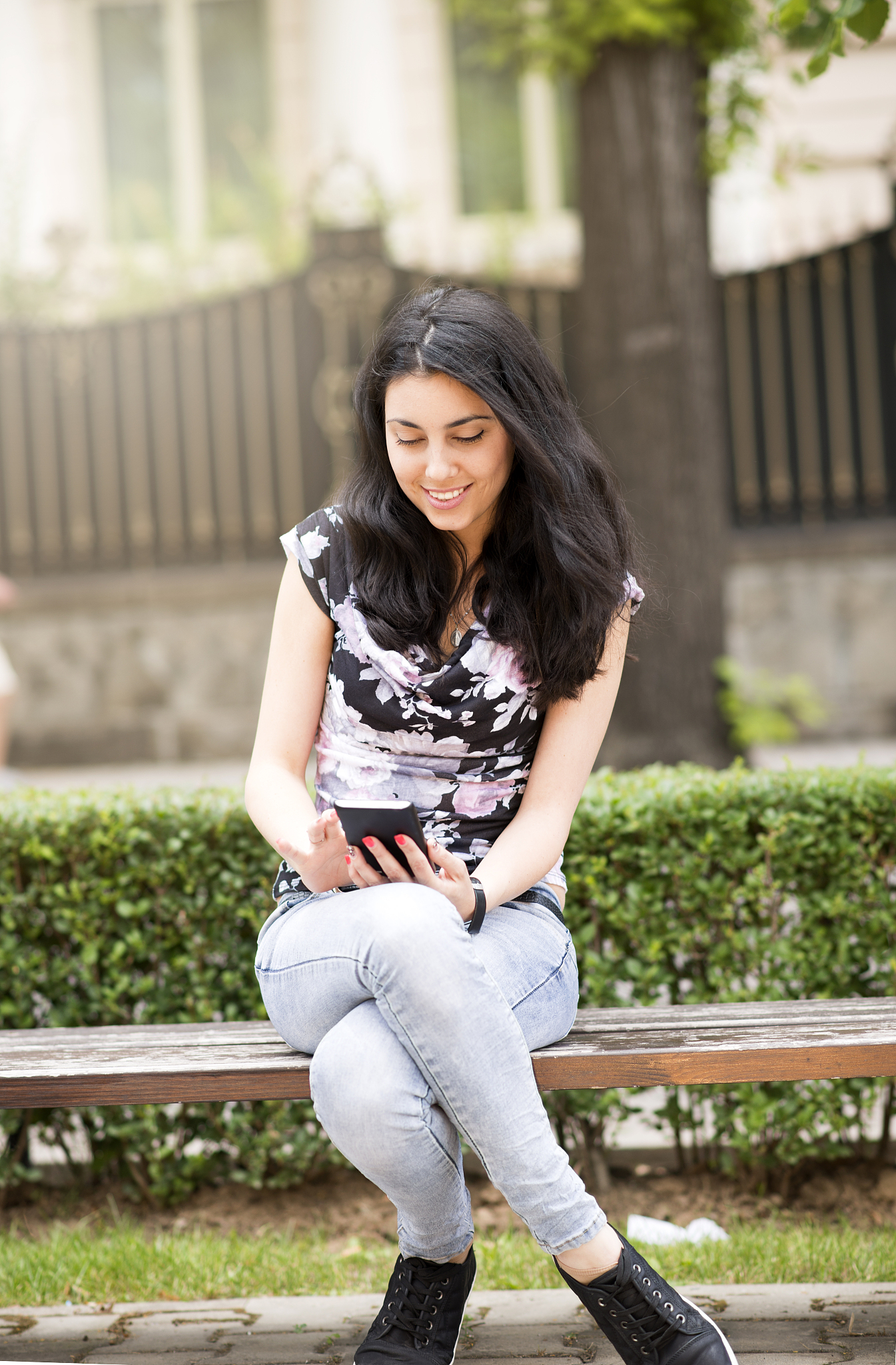 happy girl using a smart phone in a city park