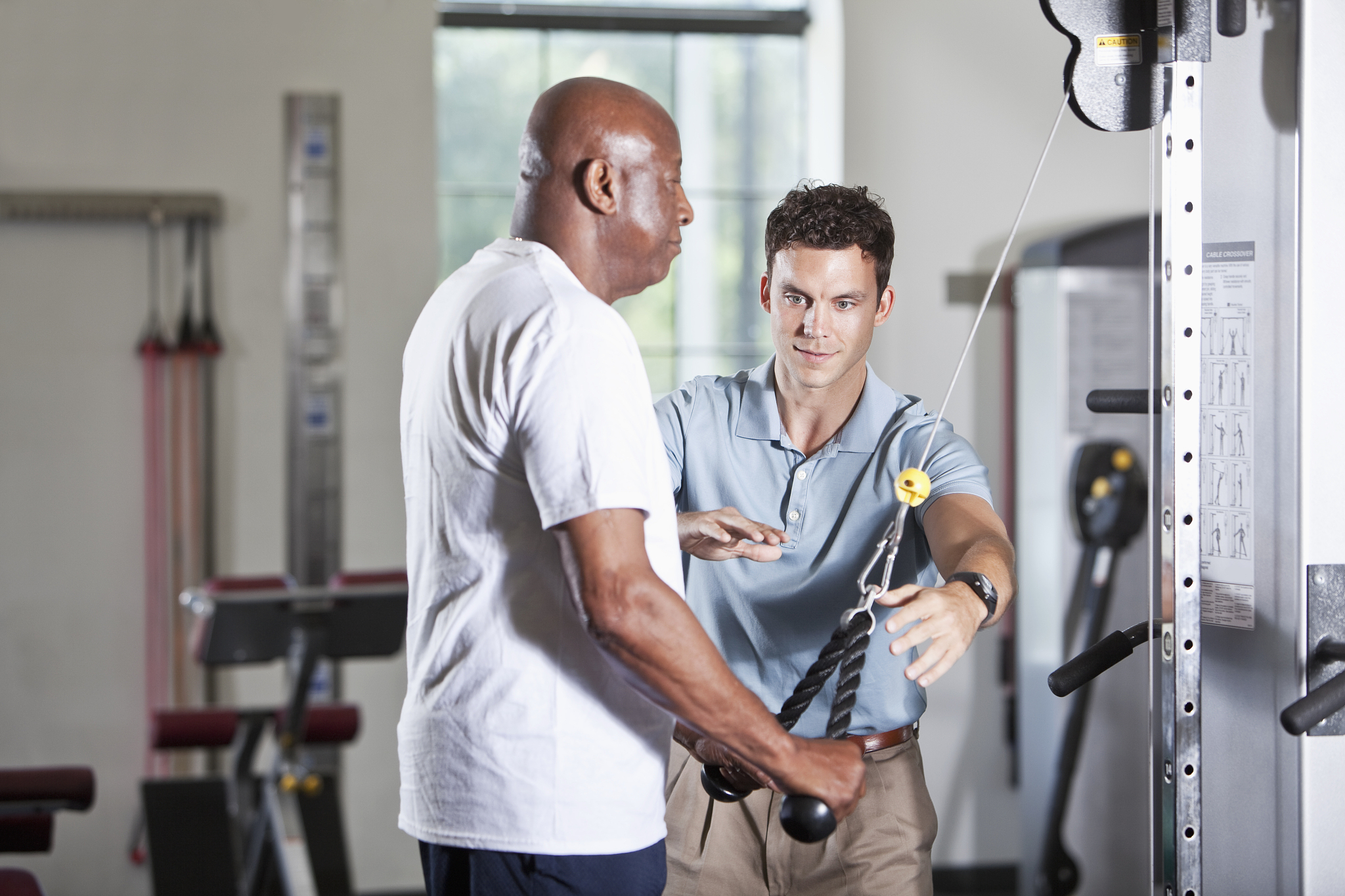 physical therapist helping african american patient