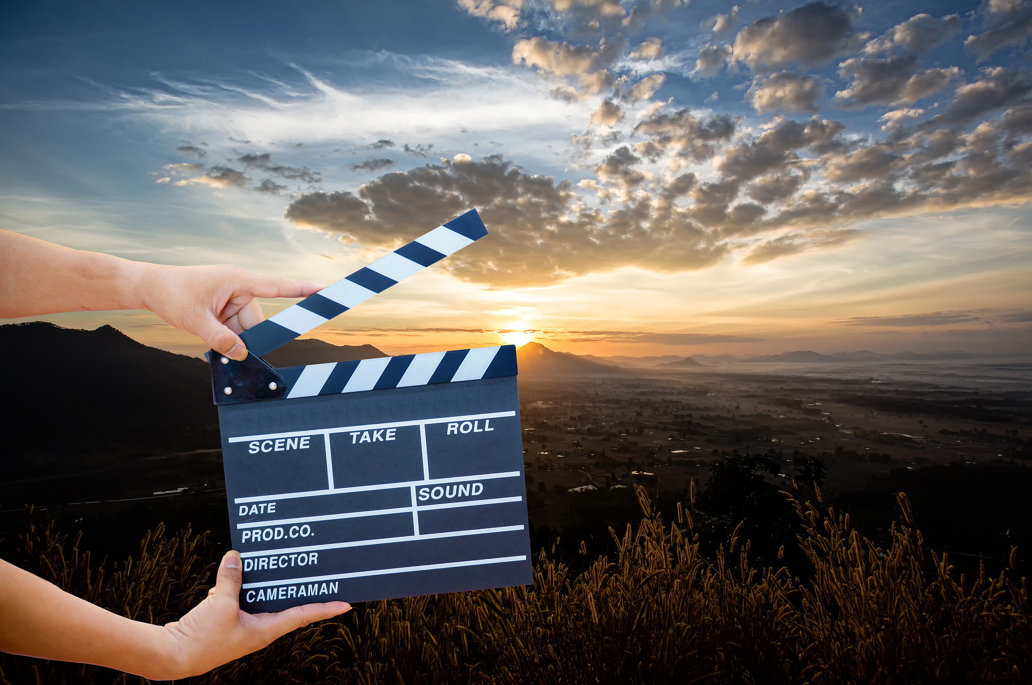 man hands holding movie clapper isolated on nature background. s