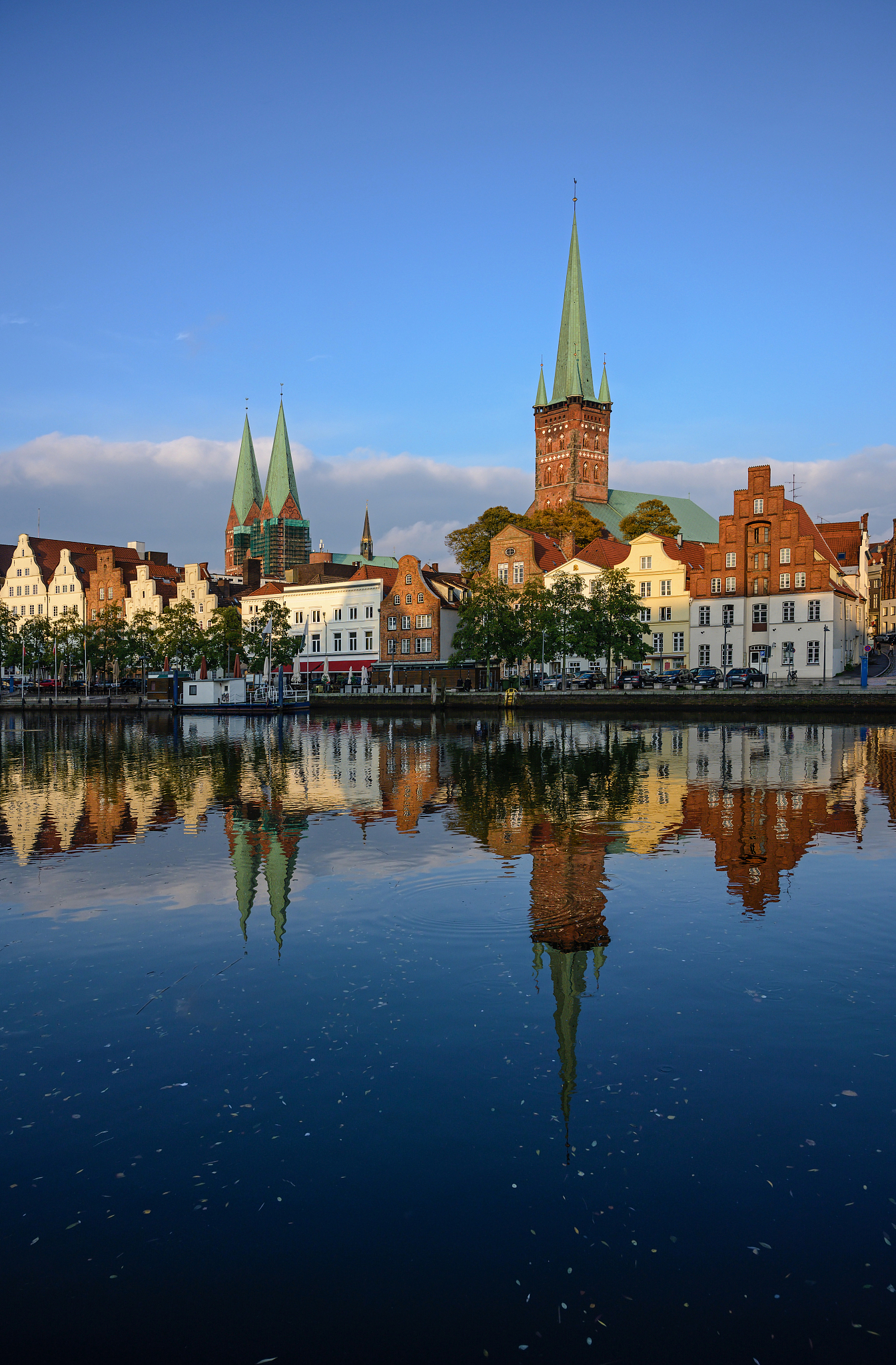 reflection of buildings in lake against blue sky