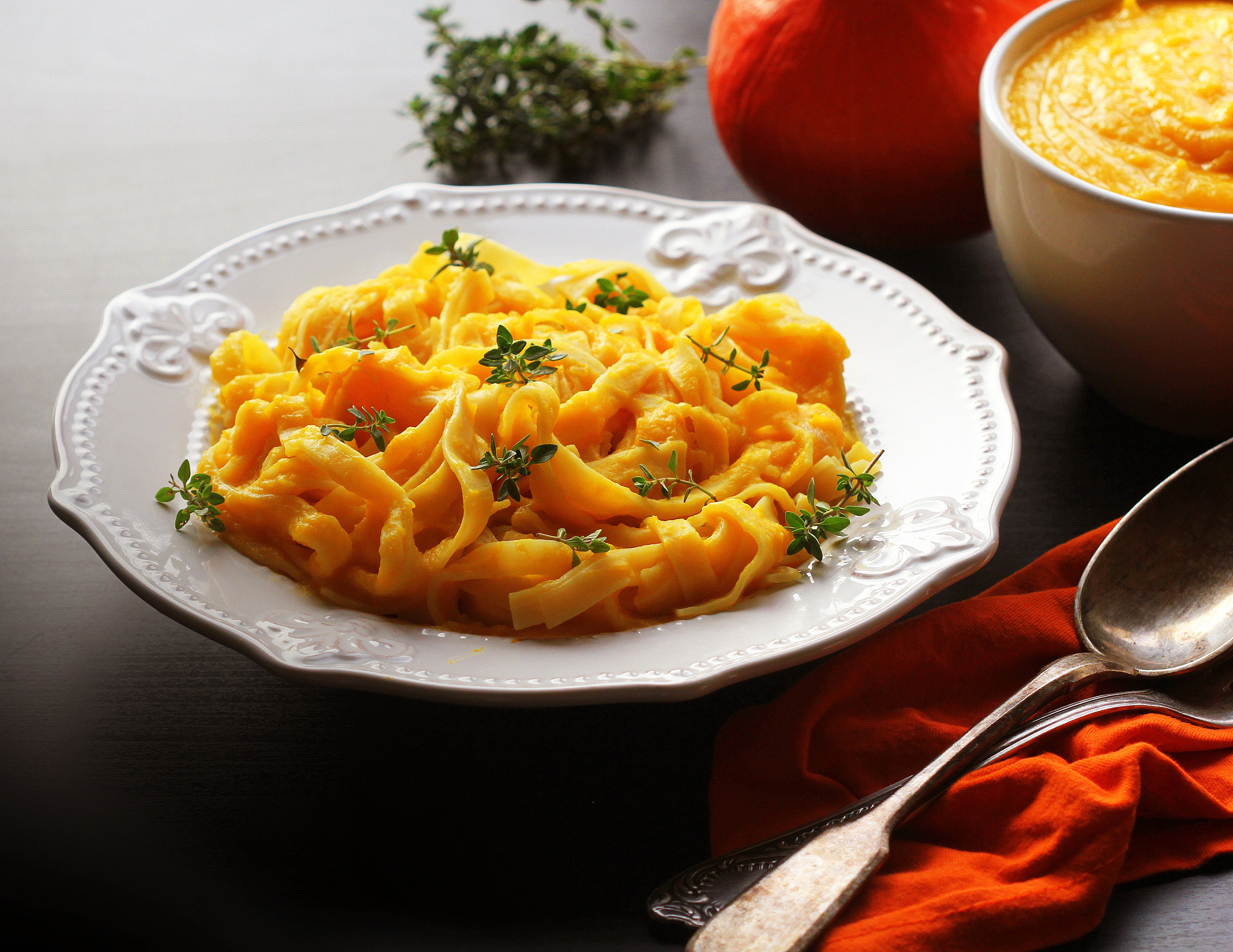 tagliatelle pasta with pumpkin cream sauce over black background