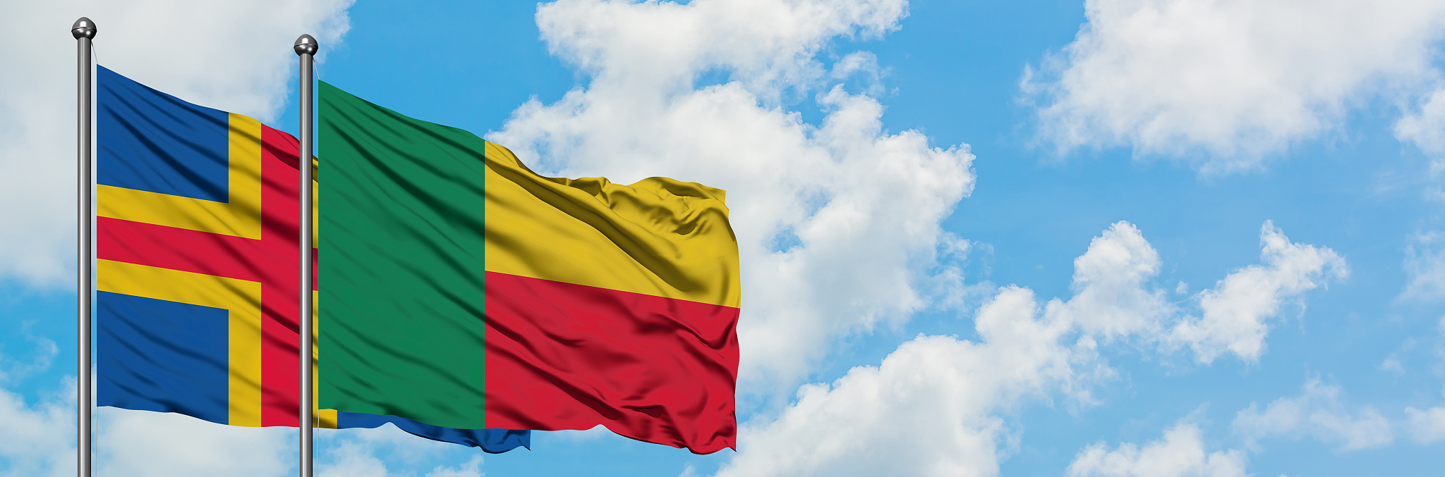 aland islands and benin flag waving in the wind against white cl