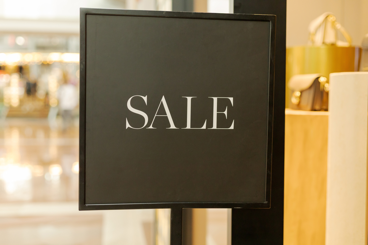 商场一家店门口立着一块写有"sale"(促销)的<strong>牌子</strong>.顾客
