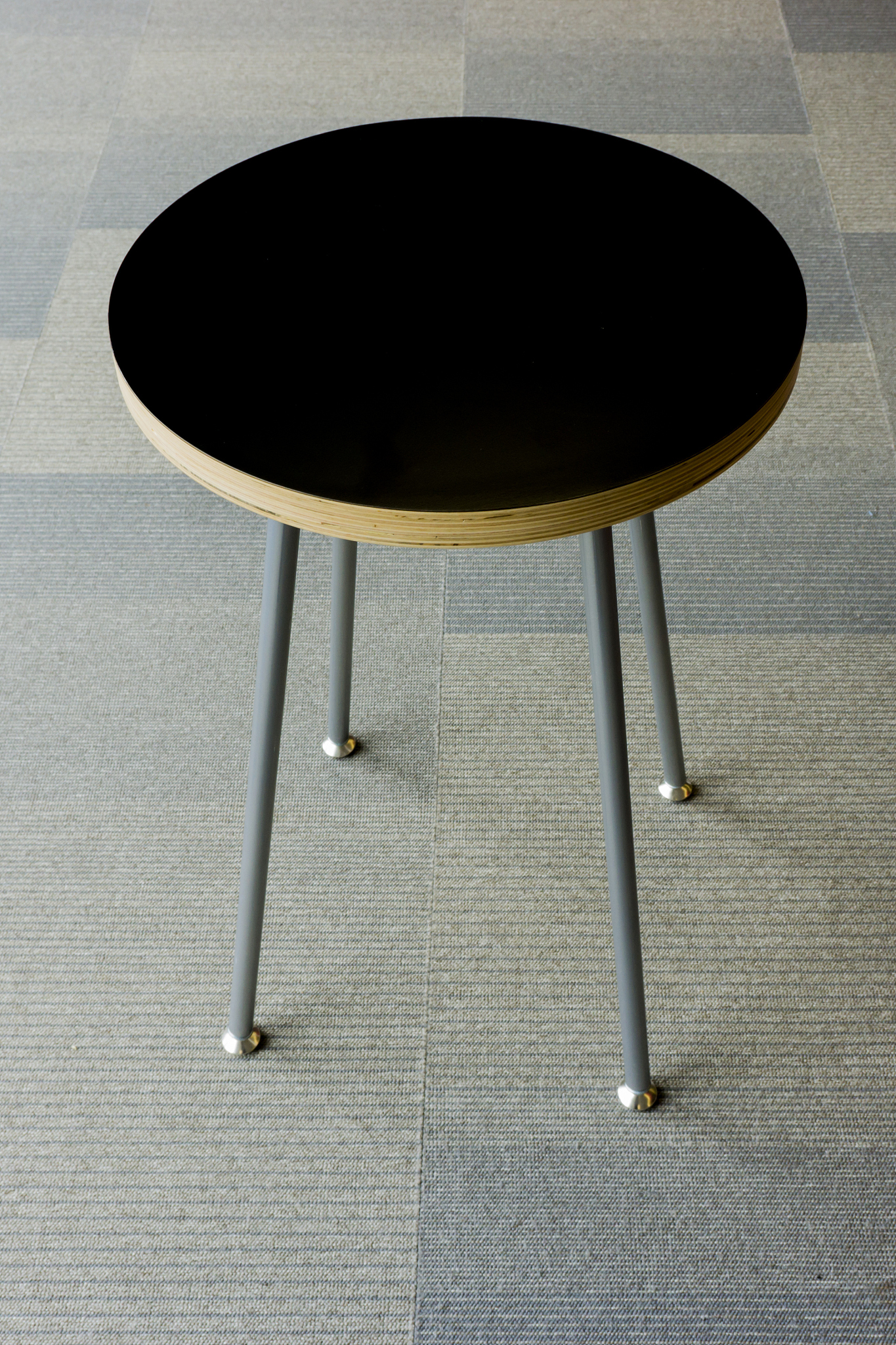 black topped end table on grey carpet