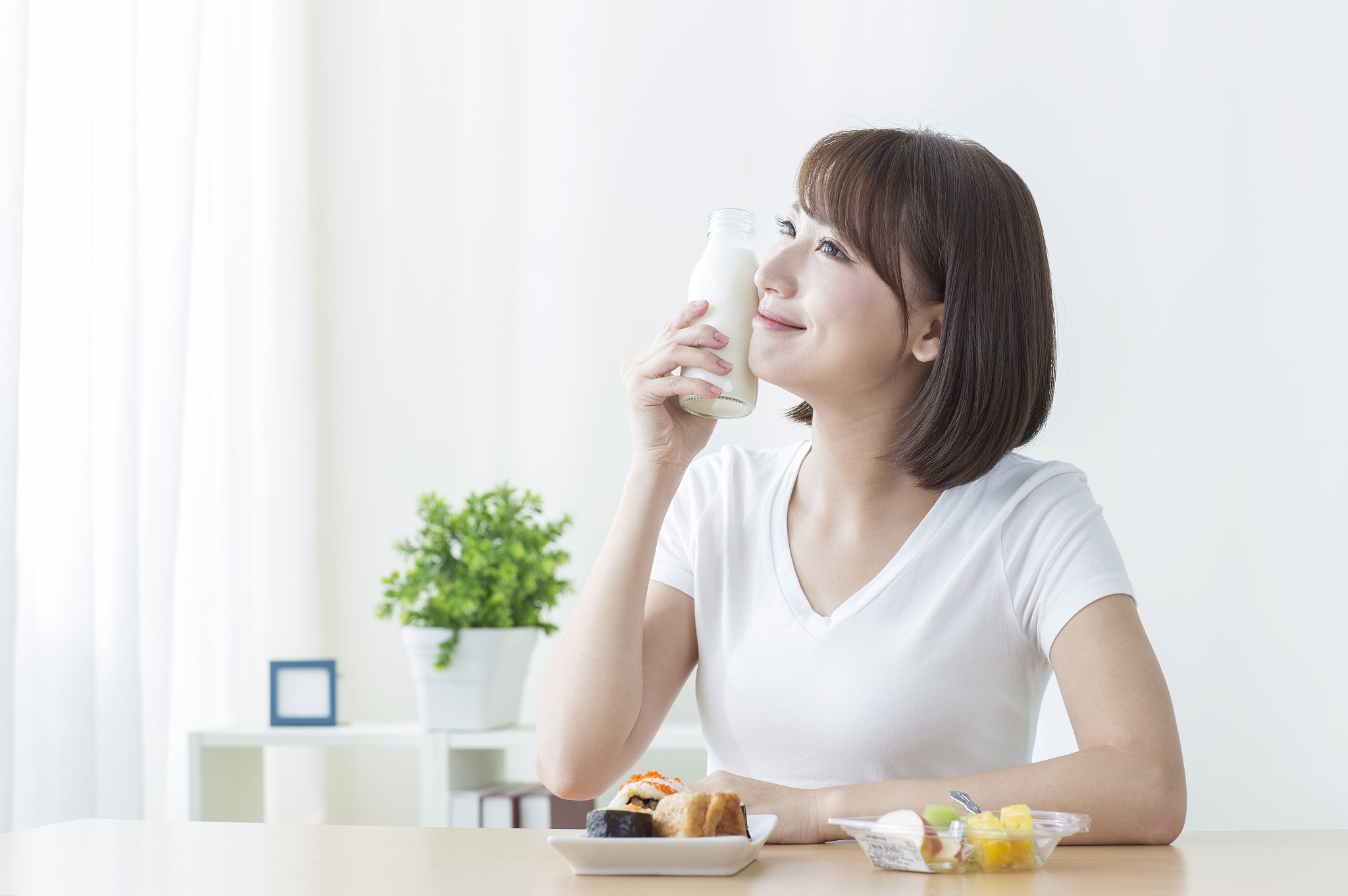 年轻女人早晨起床吃早餐