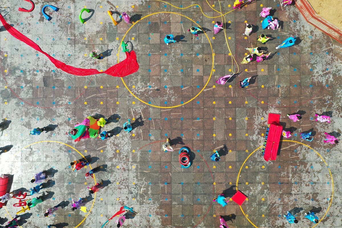 2021年5月31日,在江苏省淮安市洪泽实验幼儿园,小朋友穿着雨衣在玩打