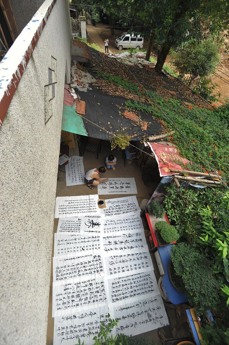 2015年7月20日,大李村一隅,严远承在自家院中研习书法.