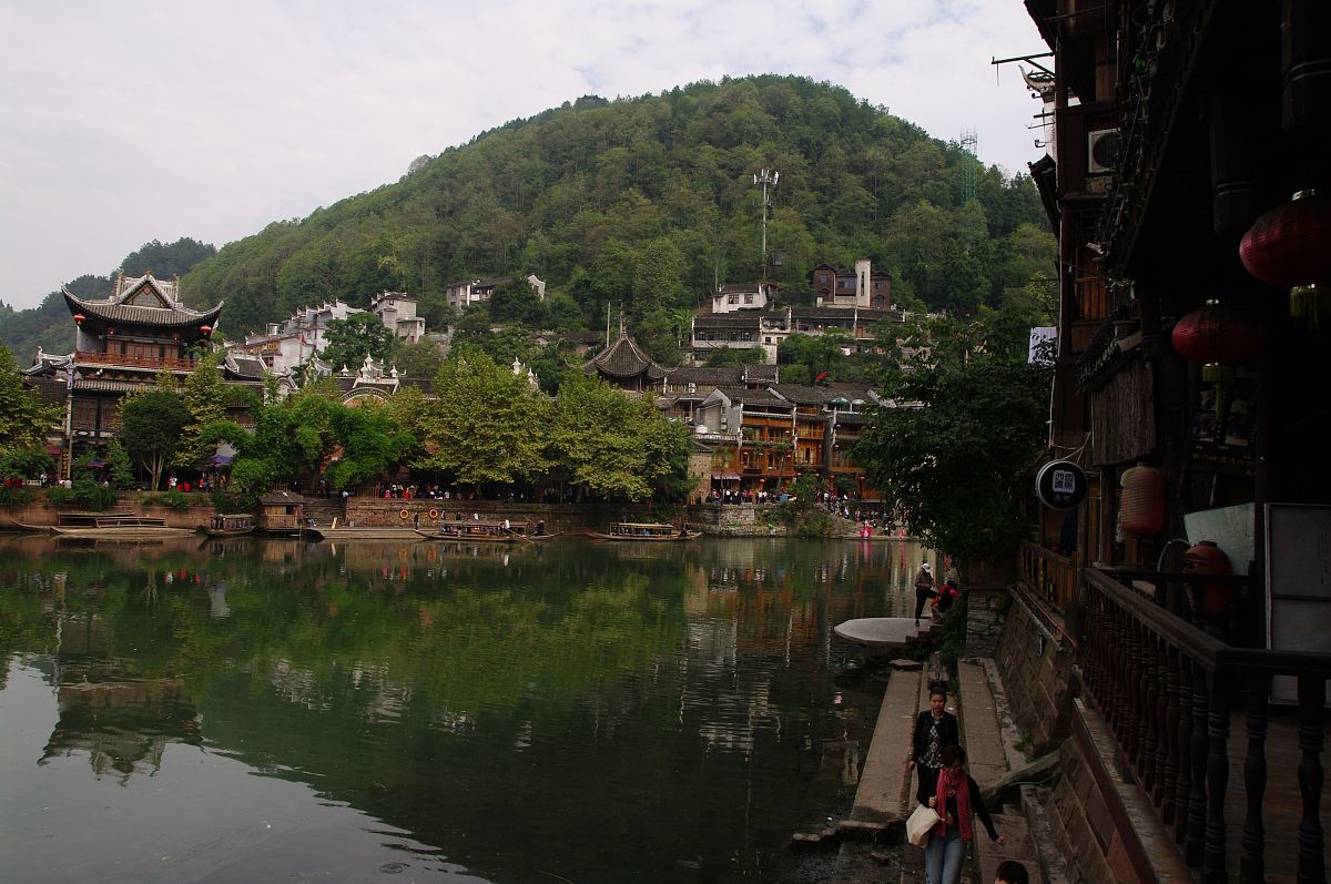 请改变语言并扩写写以下内容：把《边城》通篇读下来我读出了沈先生会湘西风情的钟爱读出了当地的人们纯朴赤诚读出了故事淡淡的忧伤。在文中先生用幽淡的笔墨向人们呈现出湿润透明的湘西美景其中那座碧溪岨的白塔给我留下了最为深刻的印象。那座立在半山腰的白塔就像是一个沉默的精灵远远地眺望着老船夫和翠翠的家默默地给予他们祝福。它就像是老船夫和翠翠心灵的港湾。每当他们有心事无处诉说他们总会出神地遥遥望着白塔让被现实束