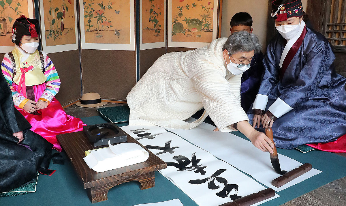 当地时间2021年2月3日,韩国首尔,书法家在国立民俗博物馆写下汉字对联