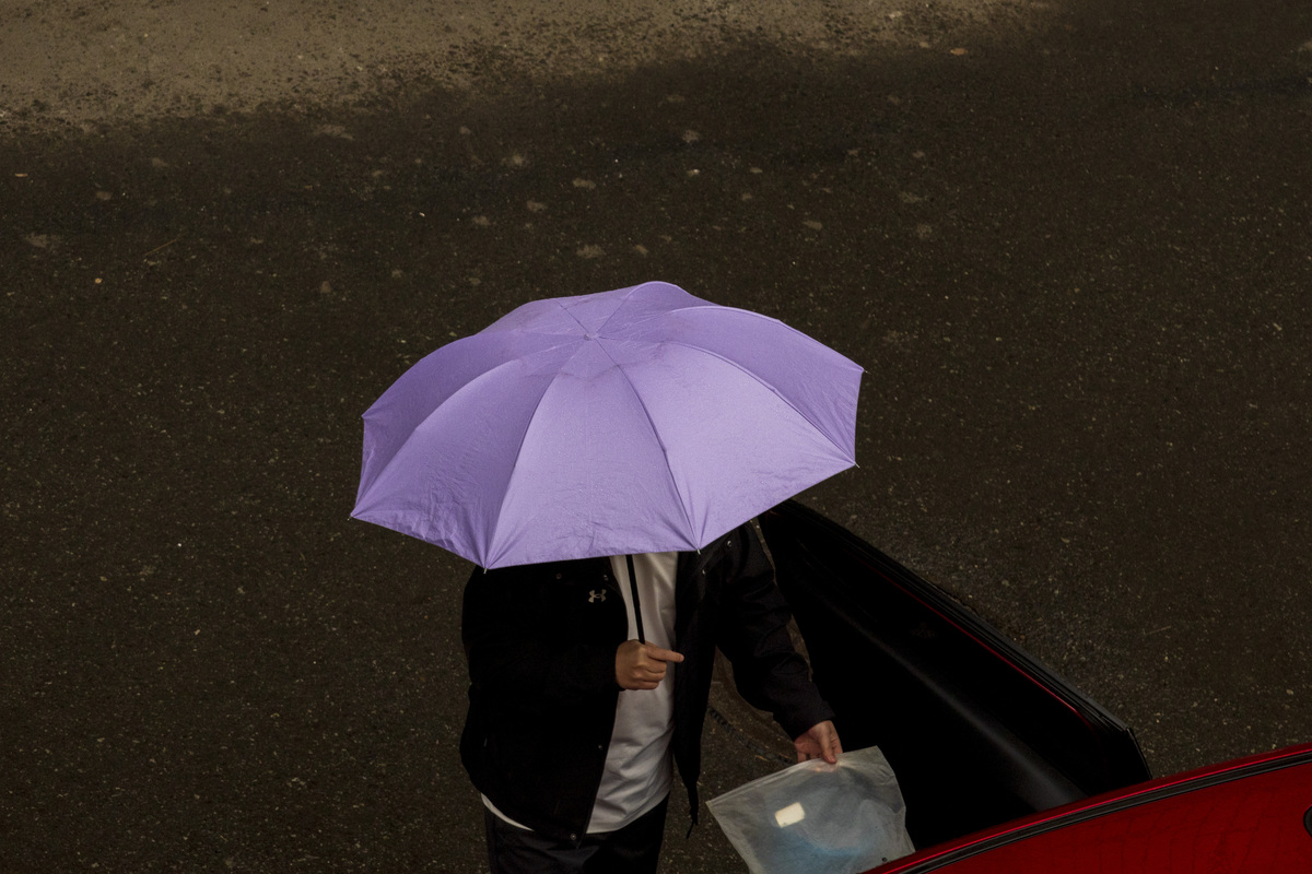 2026年4月10日,吉林省吉林市,春雨中家长接孩子放学.