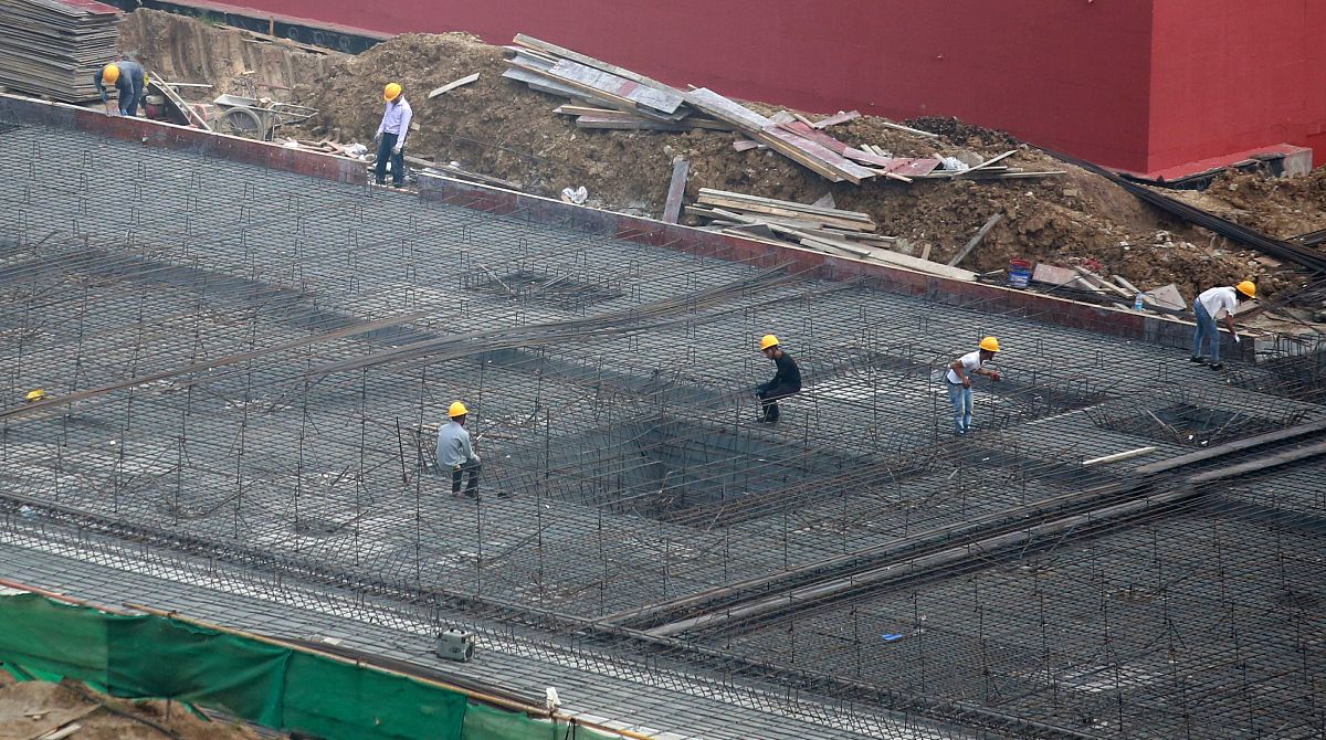 2021年10月6日,在江苏省扬州市邗江区一建筑工地,工人在施工作业.