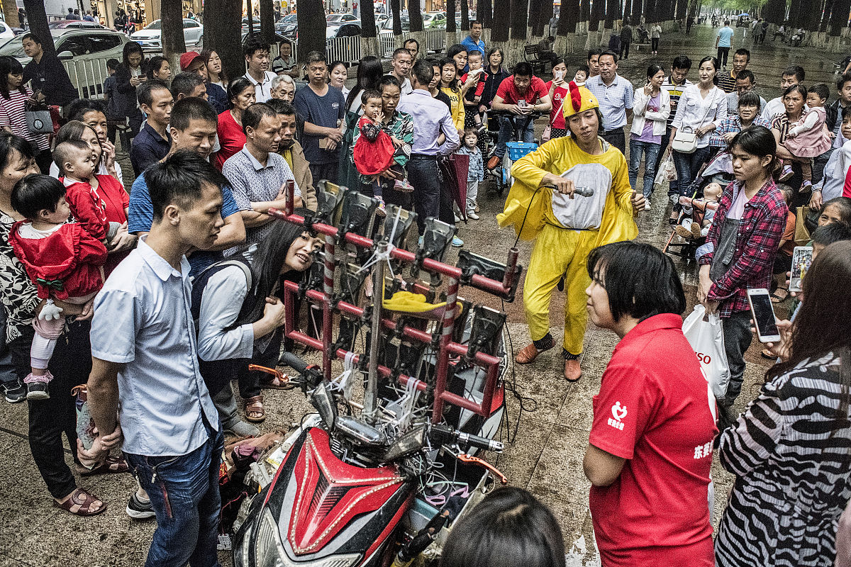 街头演员爆笑表演观众哈哈大笑。虽然有人觉得这种表演很幼稚但大多数人还是很享受这种轻松的氛围。请给上面这一段文本进行润色。