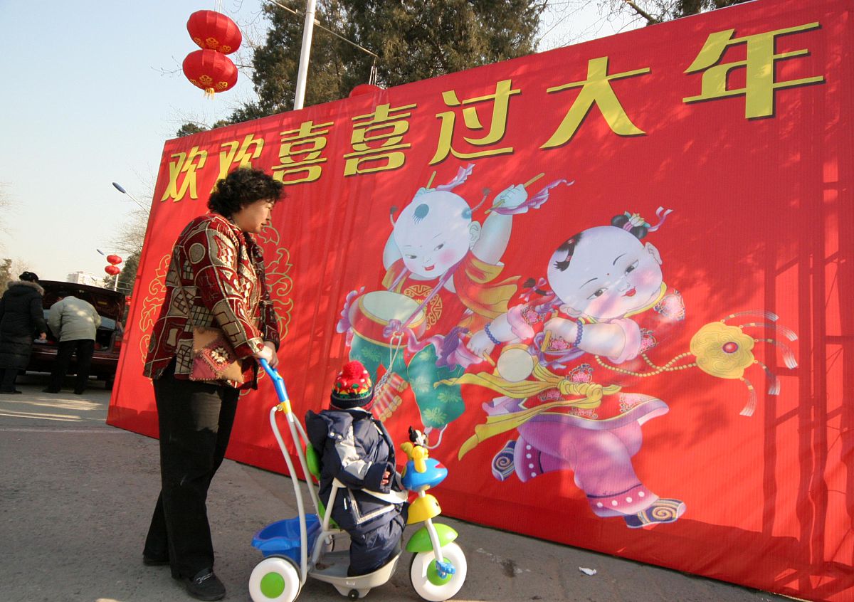 2007年2月1日,北京春节年货商品采购交易会开幕,市民推着孩子从欢欢喜