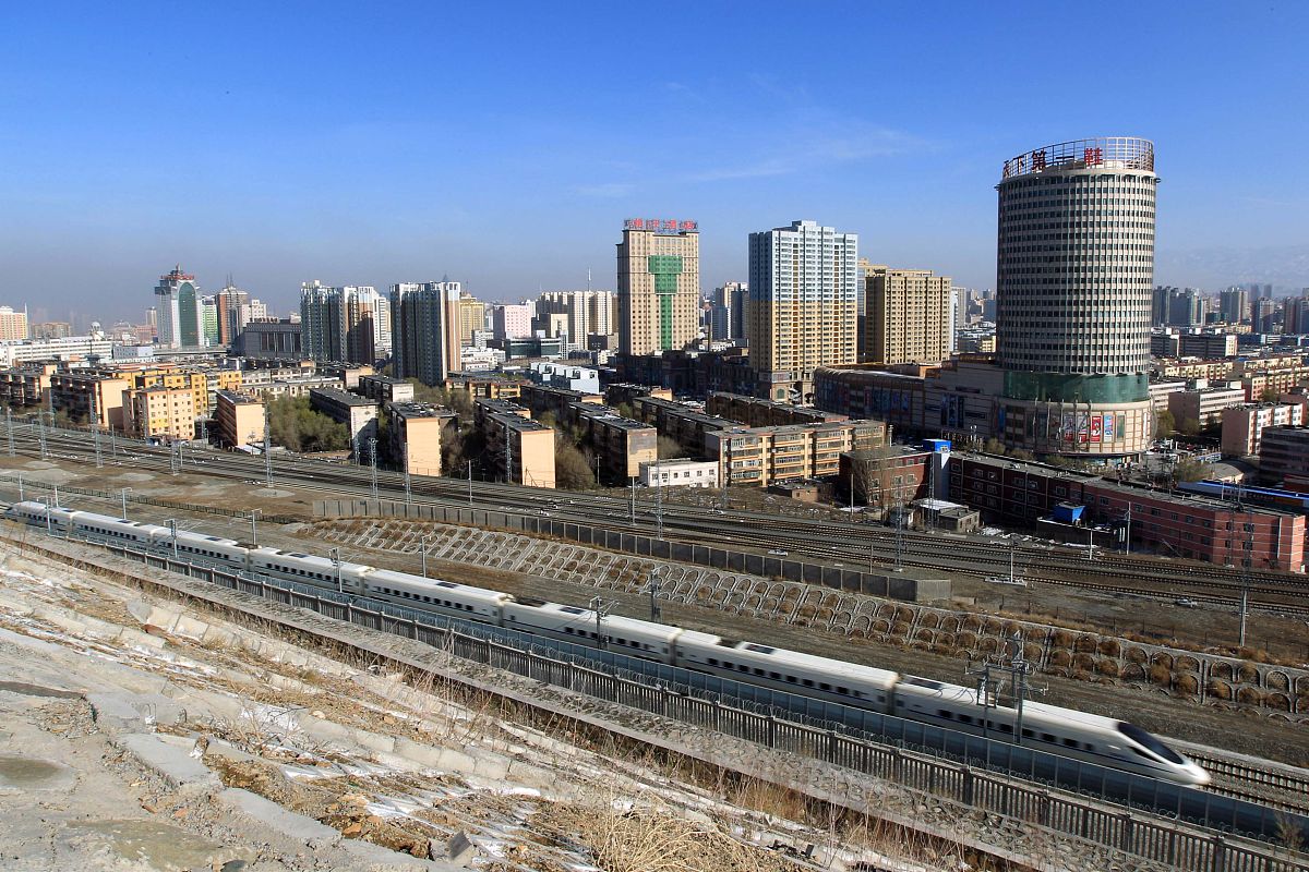 2015年11月7日,一列动车组列车从新疆乌鲁木齐城区驶过.