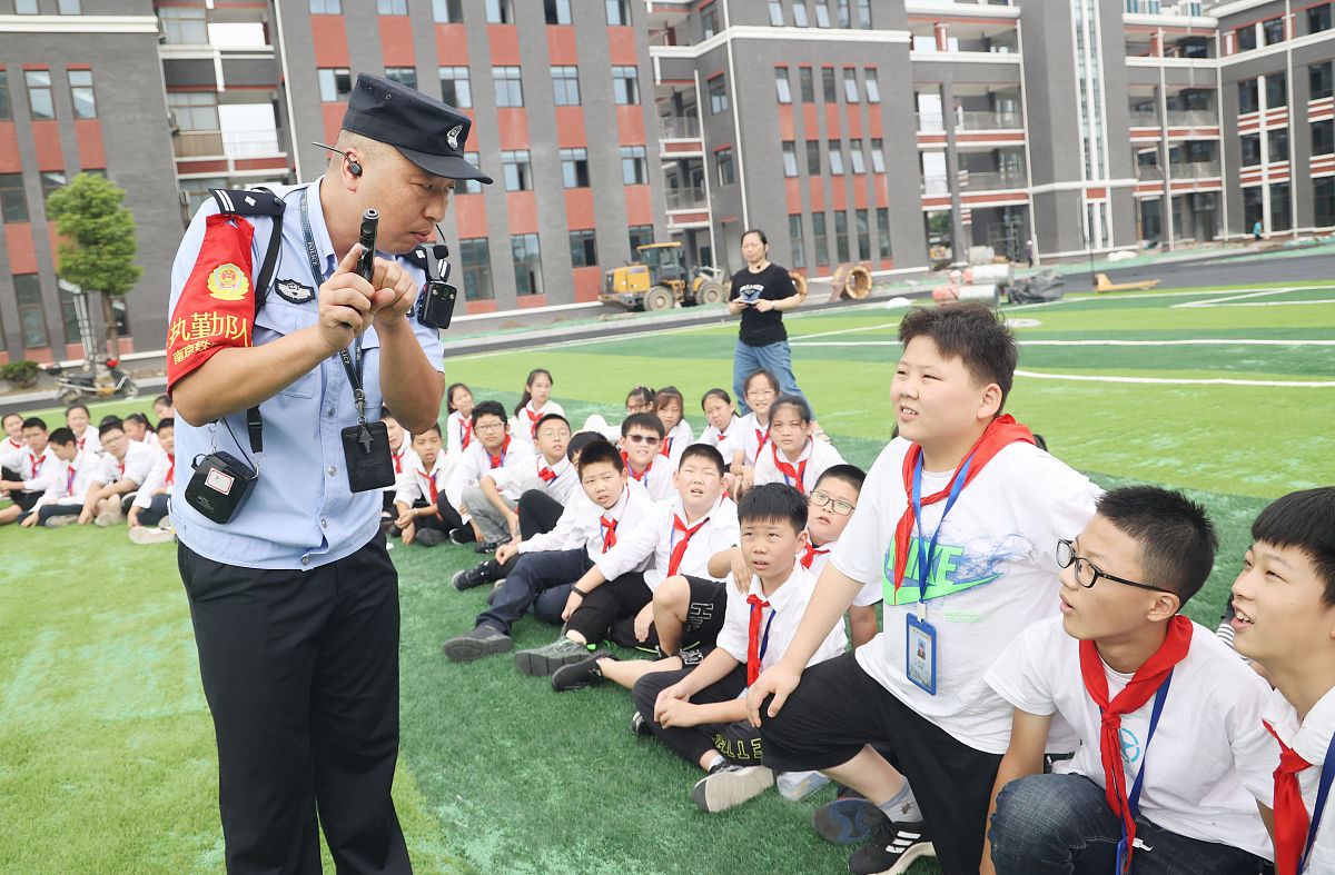 2021年9月7日,江苏南通火车站派出所的民警向学生展示枪械.