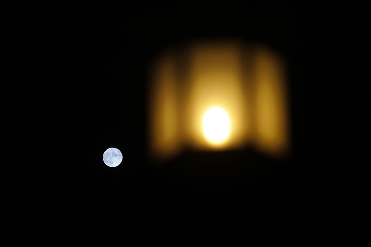 2021年9月21日,北京,满月与街边的灯笼相映成趣.
