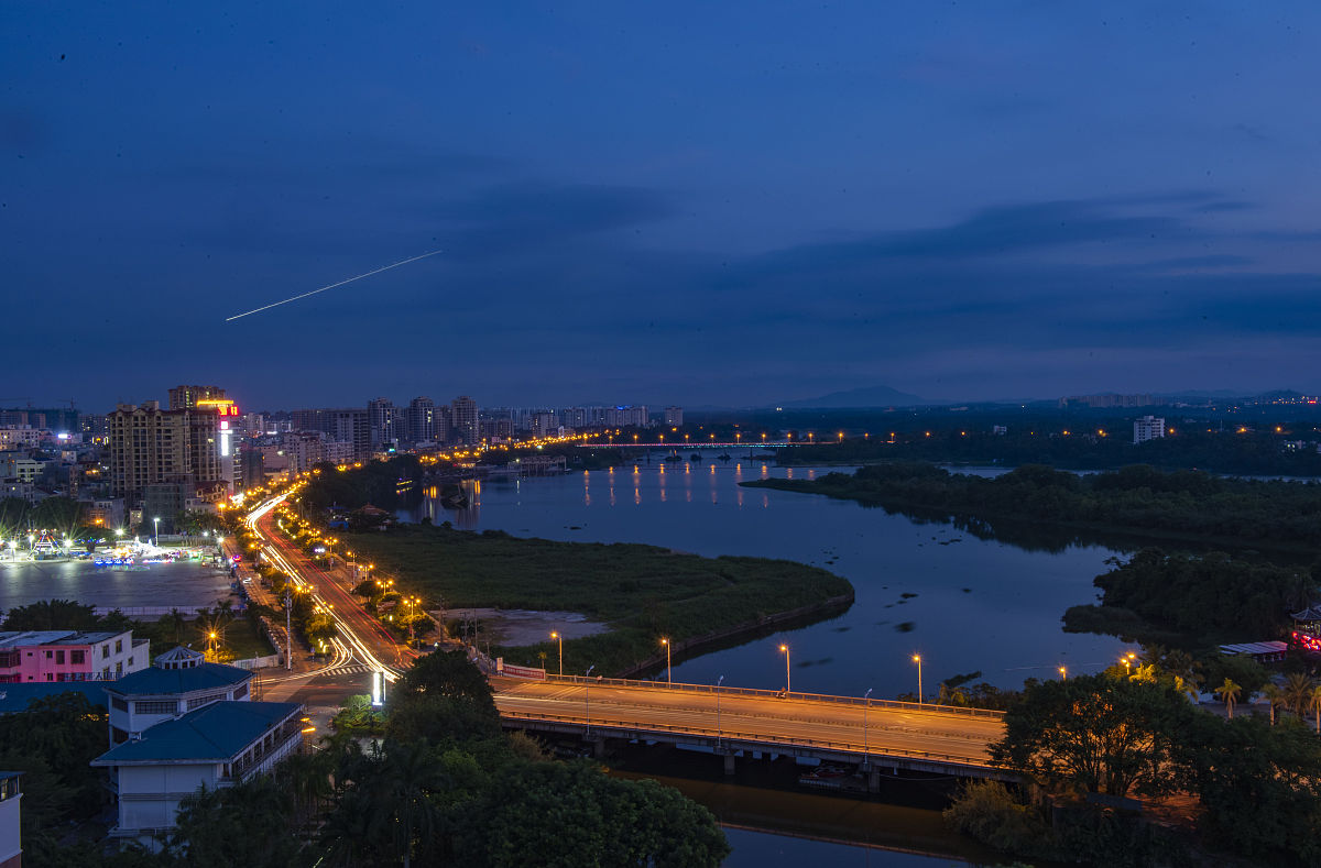 2020年9月2日,海南琼海,暮色中从天高云淡的万泉河上空飞过的飞机在空