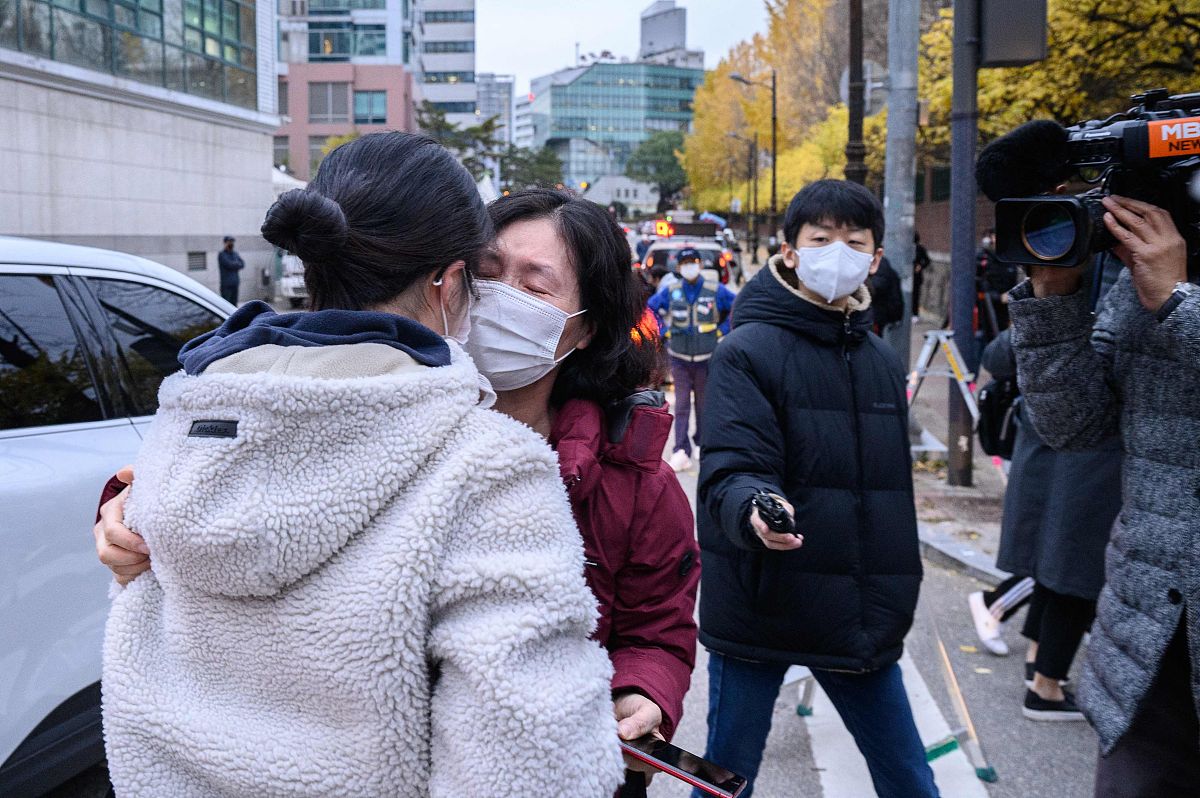 当地时间2021年11月18日,韩国首尔,家长在拥抱鼓励考生.韩国2022学年