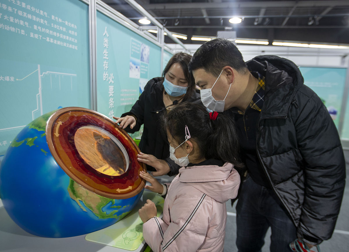 2022年1月2日,在江苏省泰州科技馆,科技辅导员李纪娟正在通过转盘为小
