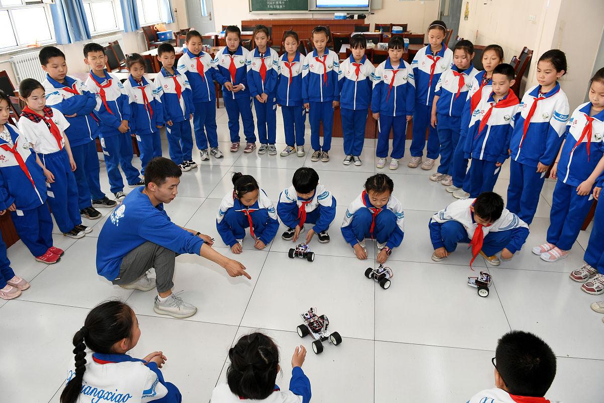 2021年5月19日,河北张家口,相国庙街小学教师带学生操作机器人.