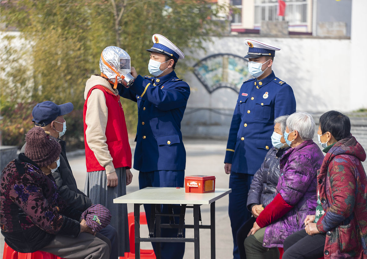 2022年3月3日,在江苏省泰州市海陵区九龙镇姚家社区,志愿者向居民示范