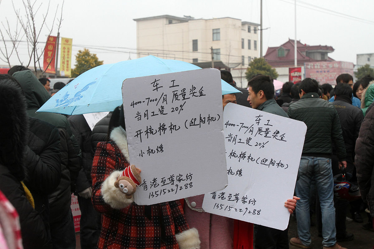   2014年2月19日,众多举着招工牌子的家纺企业招工人员聚集在江苏南通